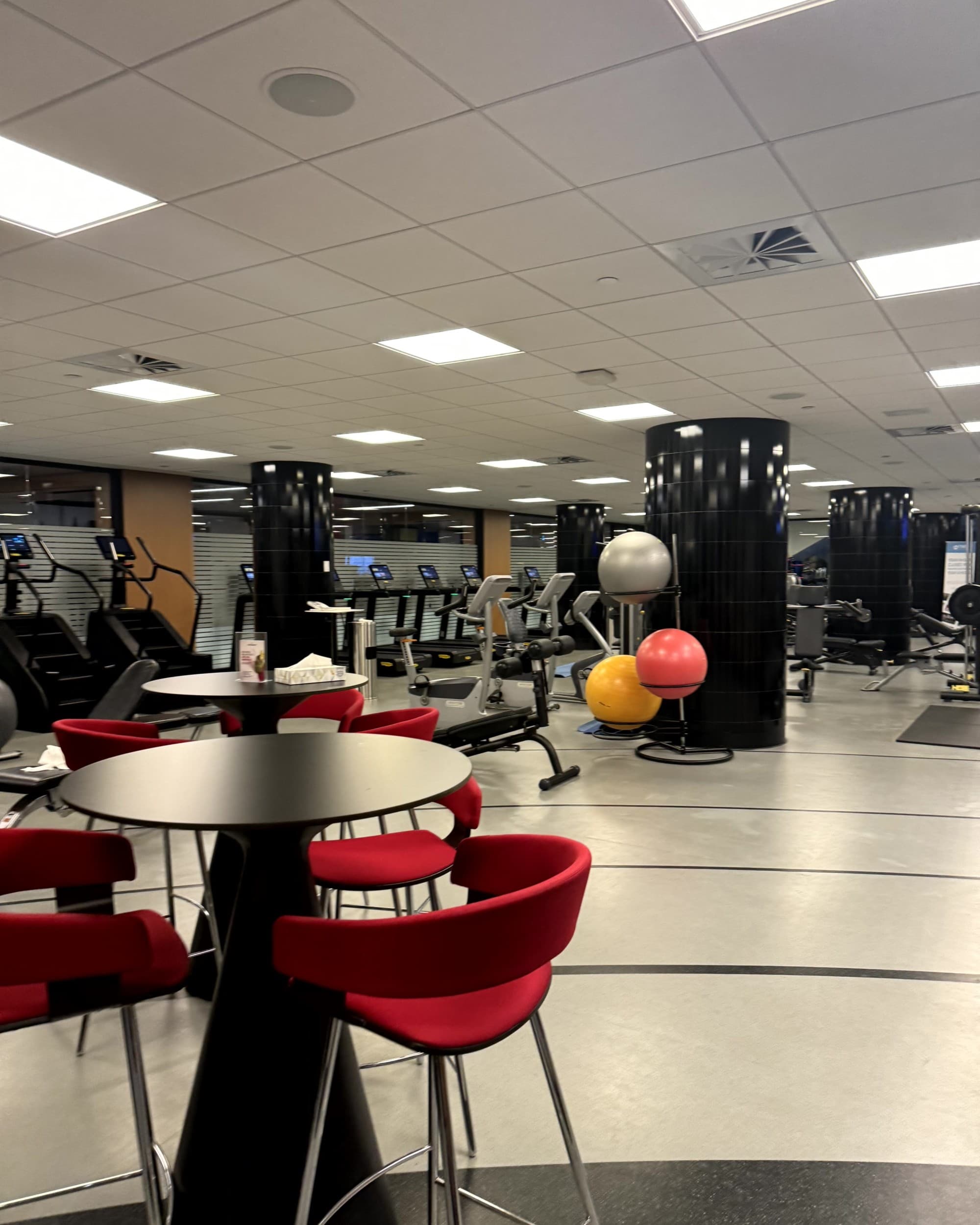 A large brightly lit gym with equipment, tables and chairs. Wellness Amenities - Gym - Rondene Grinam