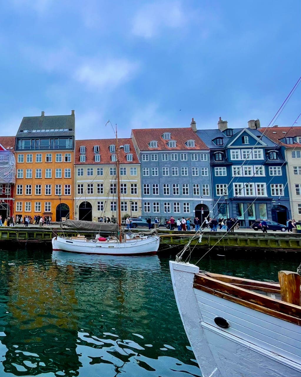 Colorful townhouses along a canal with boats at Copenhagen Nyhavn - Leah Chen