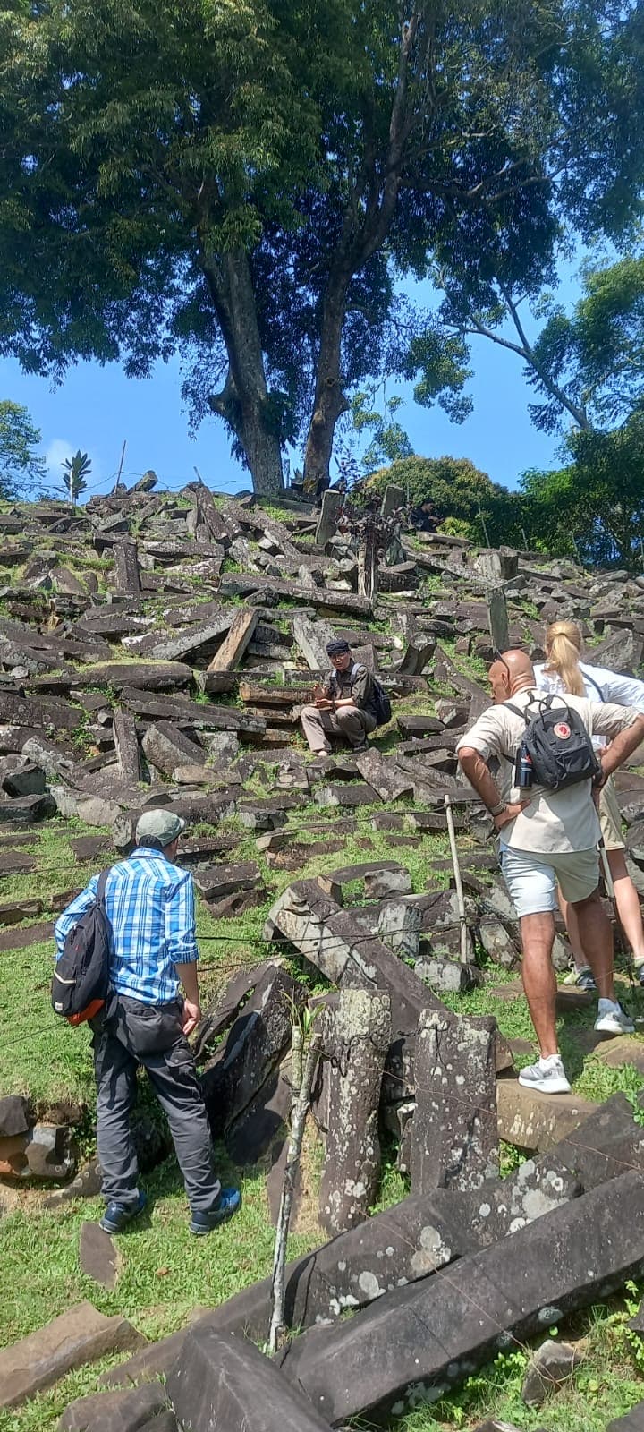 Tourists walking around a historical stone site.