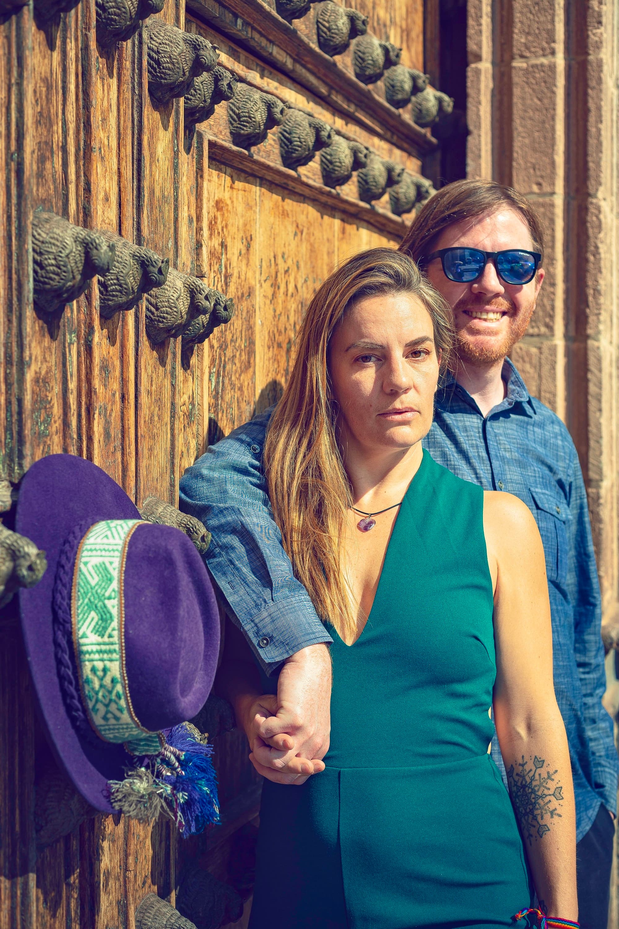 Couple posing in front of a wooden door.