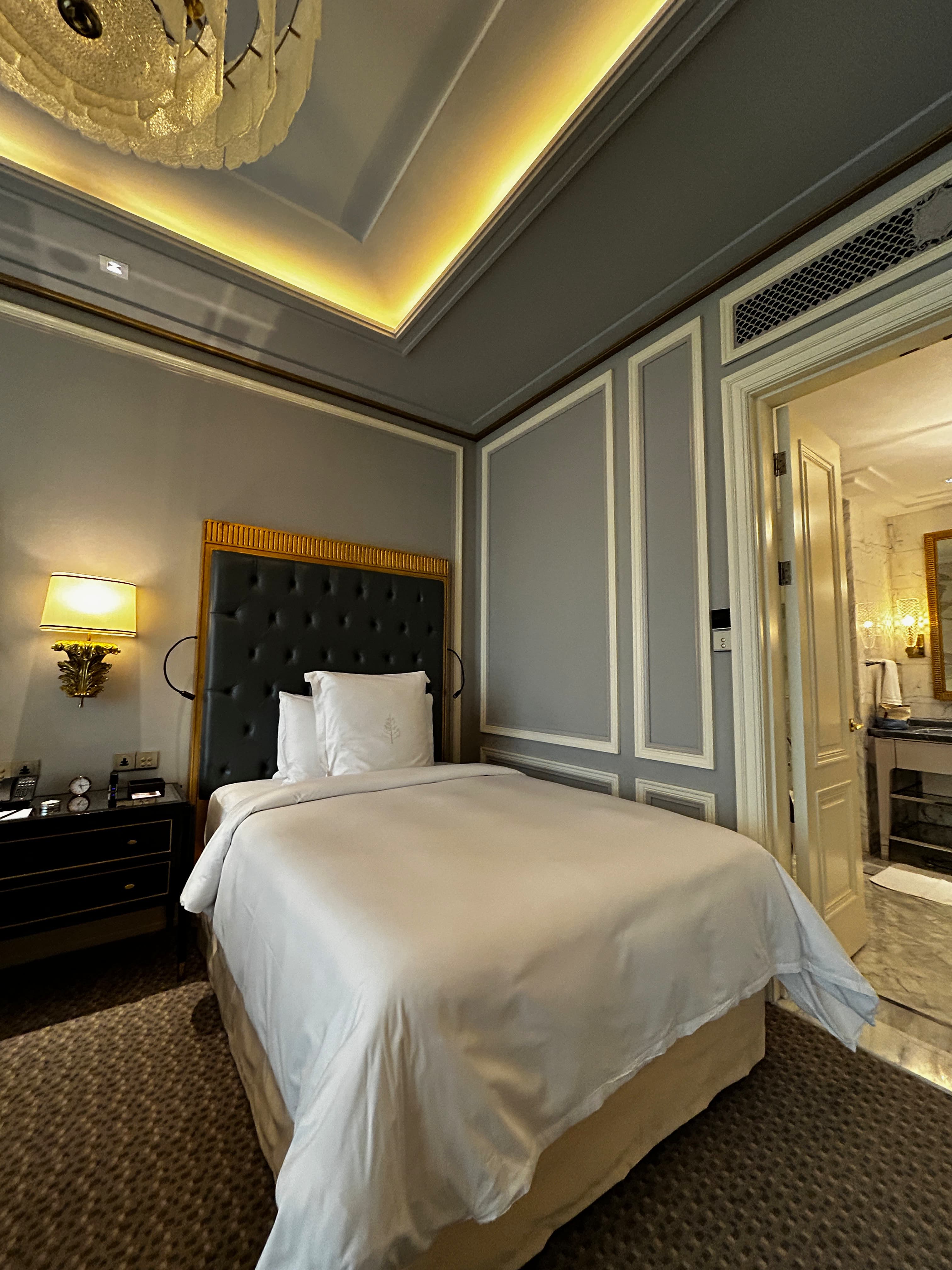 A bedroom area at Four Seasons Jakarta with white bedding and elegant fixtures.
-