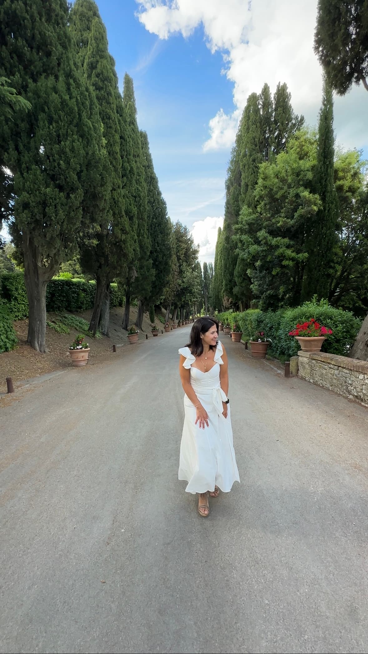 Advisor posing along the cypress-lined driveway on a clear day.