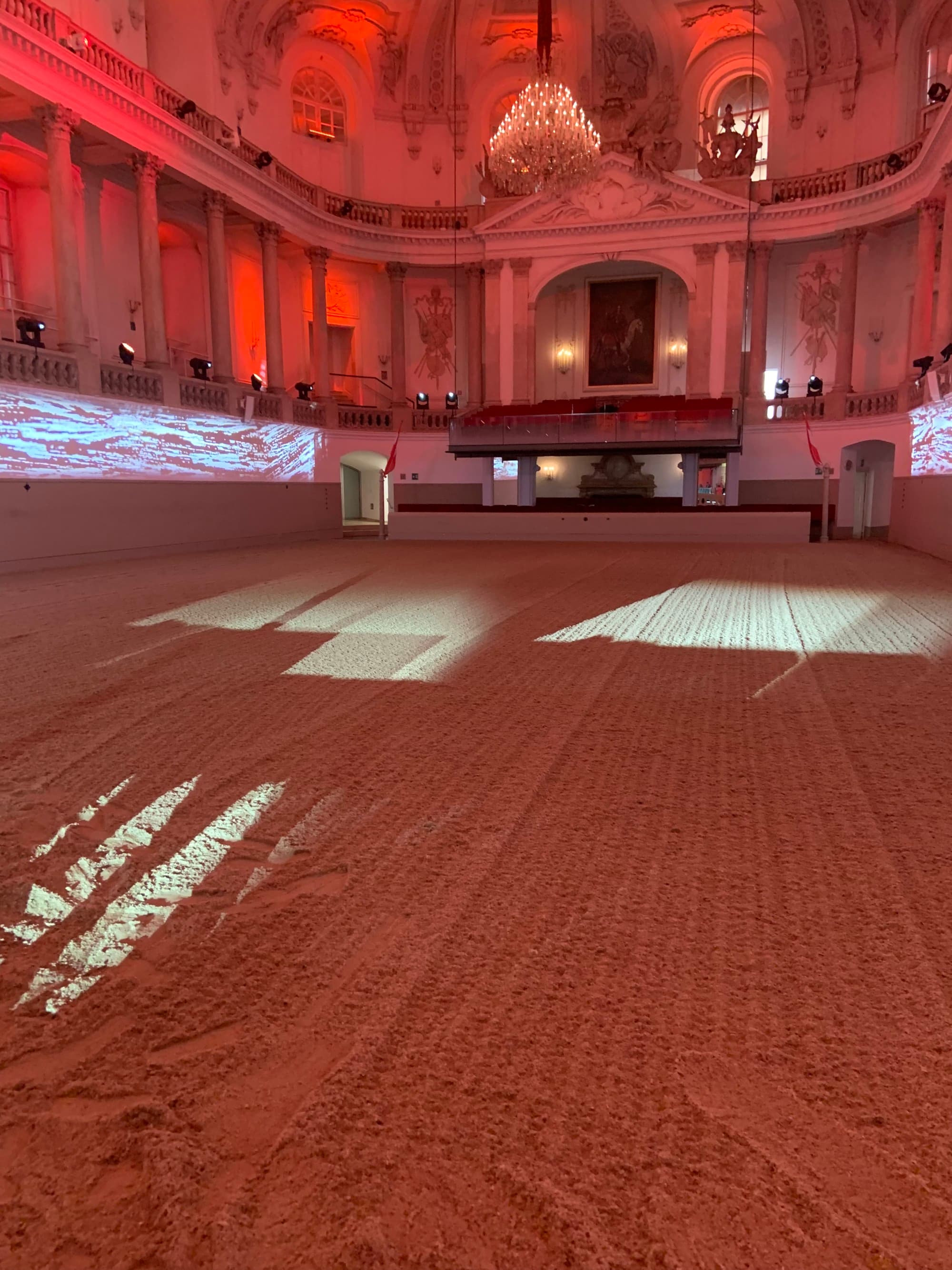 The interior of a grand building illuminated with red lighting.