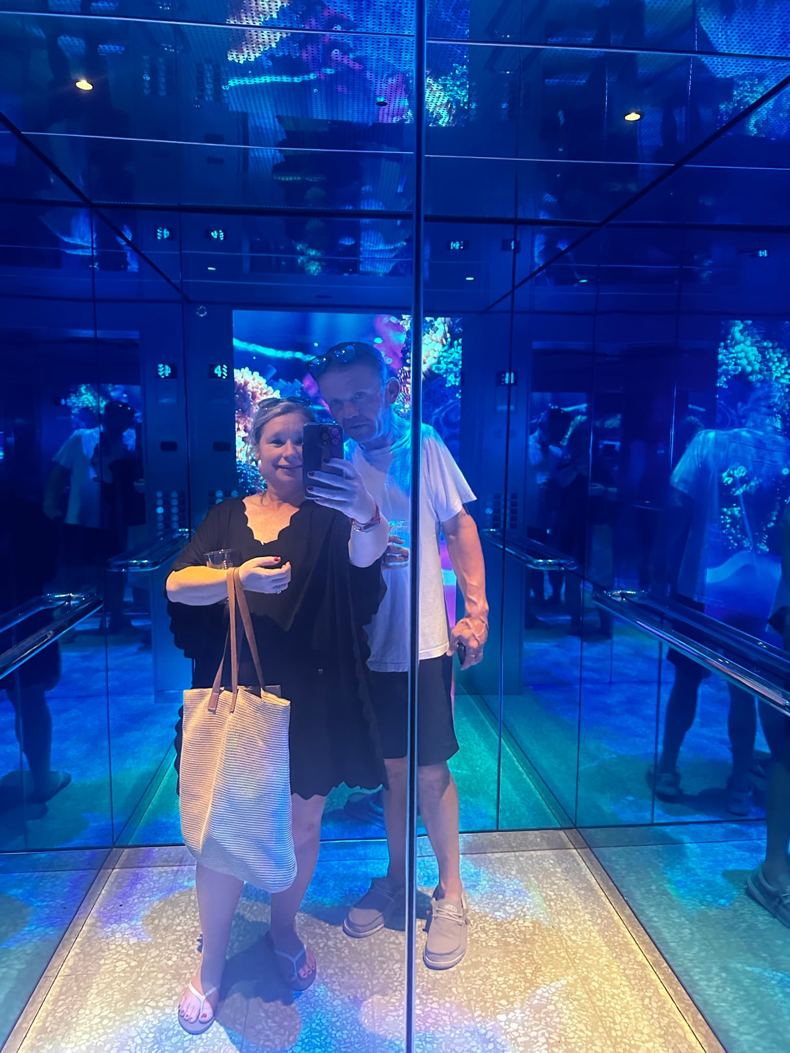 Shelly and her husband taking a selfie in the elevator on Scarlet Lady - Shelly Maffia