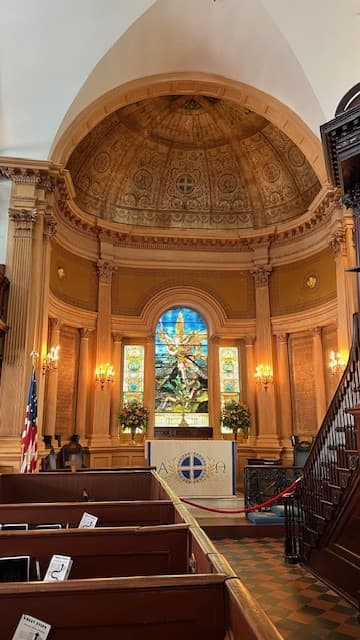 A church with a wooden pulpit and stained glass.