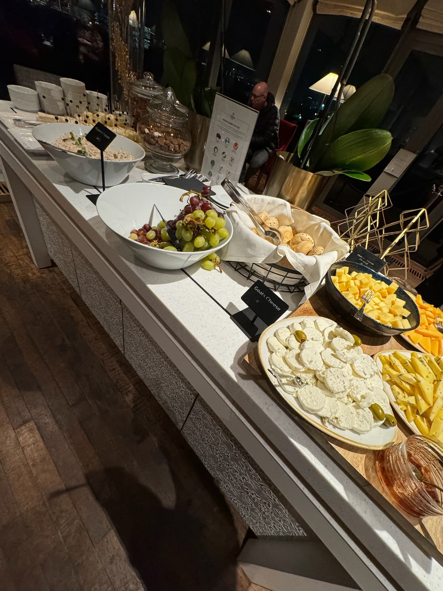 A buffet spread with cheese, crackers and grapes.