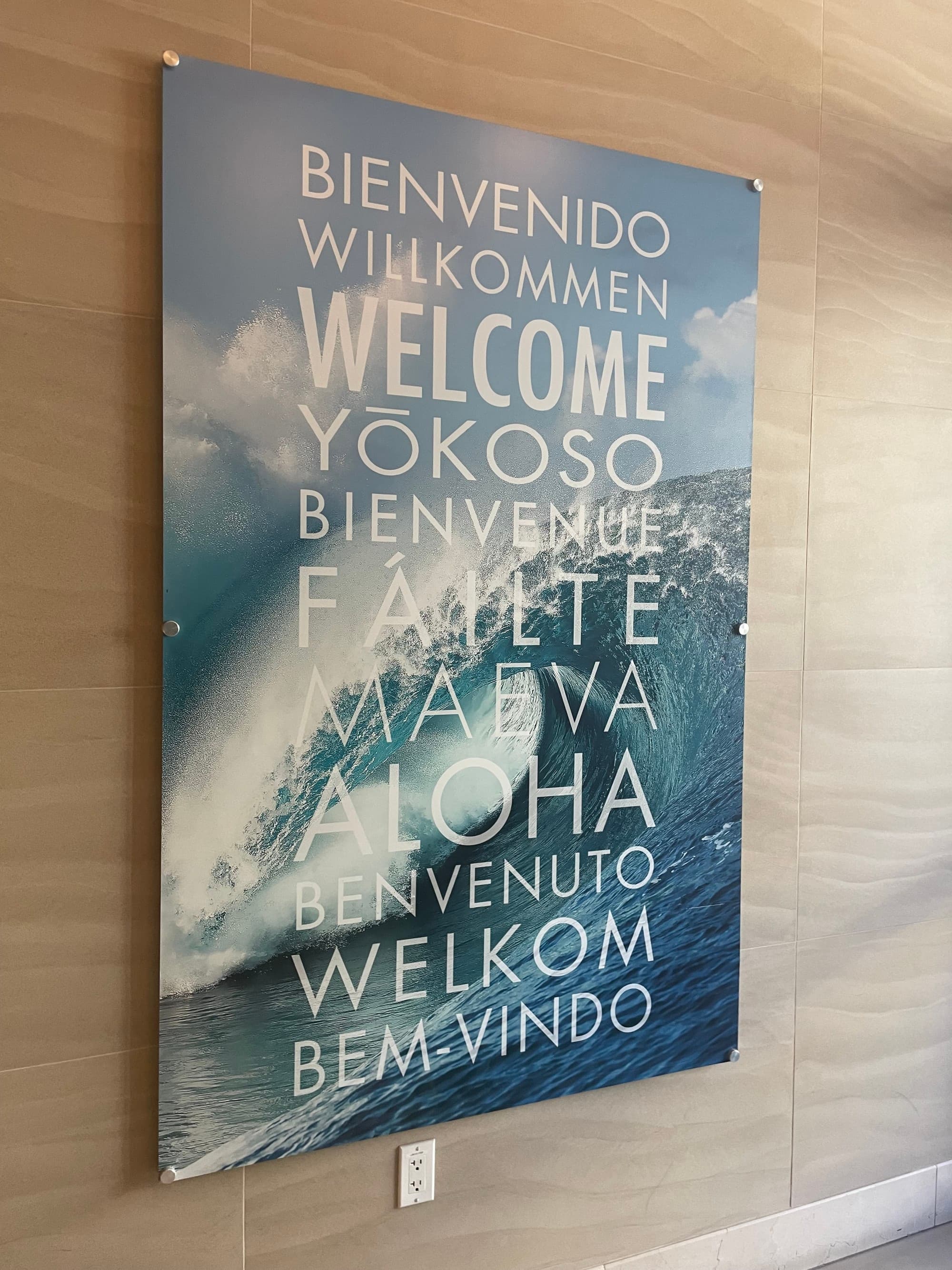 Pasea welcome sign, with "welcome" in different languages over an image of waves - Michelle Roe