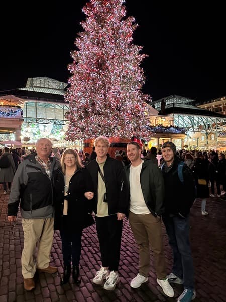 Travel advisor and family posing in front of the lit up and decorated Christmas tree at Covent Garden.