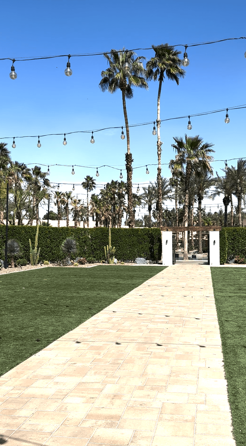 A brick pathway through a green field during the daytime