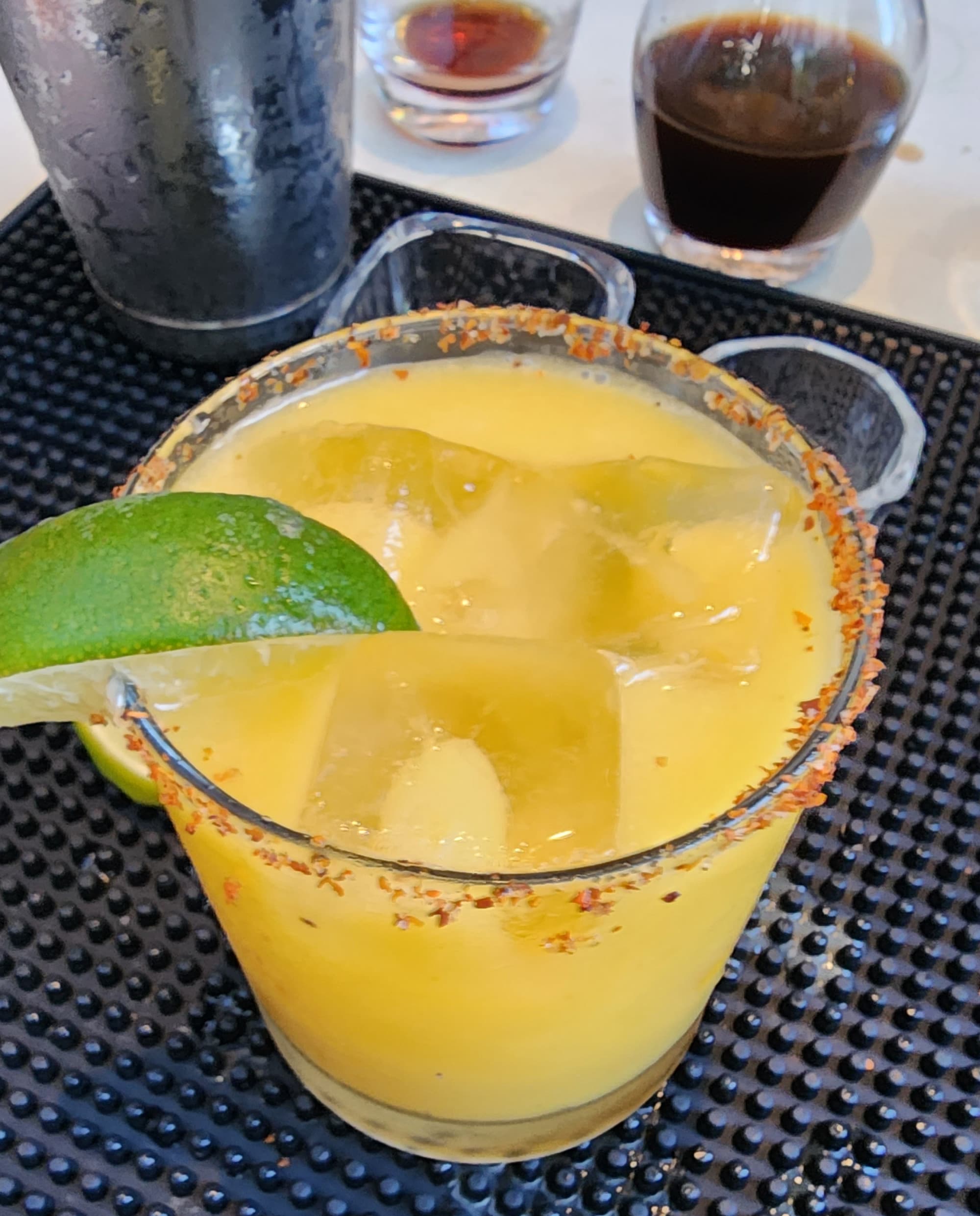An aerial view of a cocktail with lime and salted chile rim