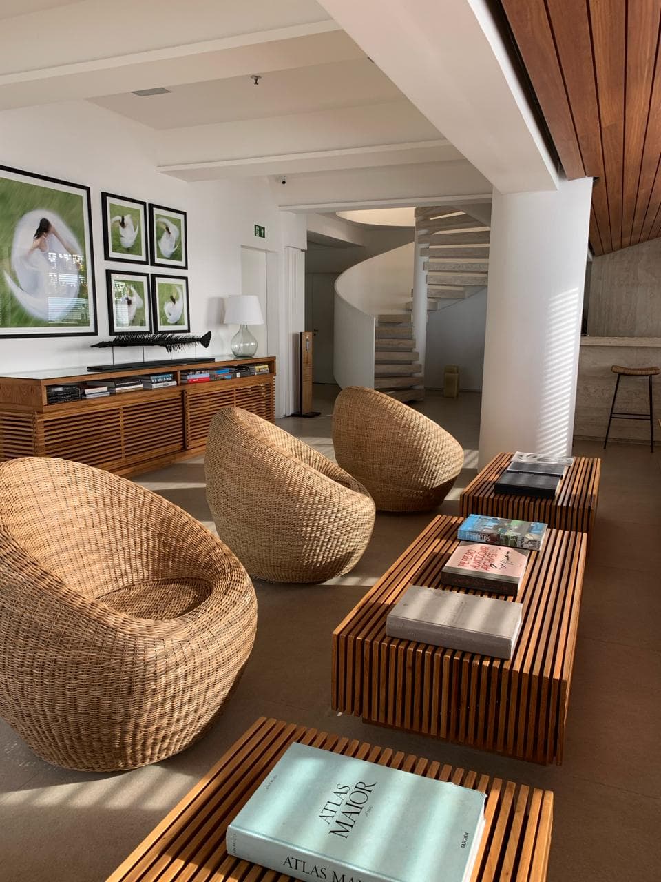 Sitting area in hotel with wicker armchairs and paintings on the wall