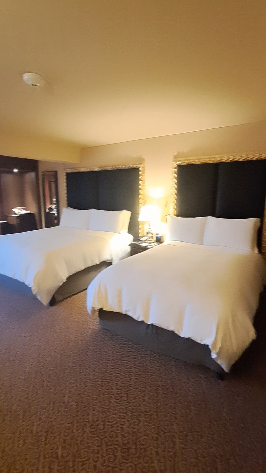 Hotel room showing two double beds with white bedding and tall headboards