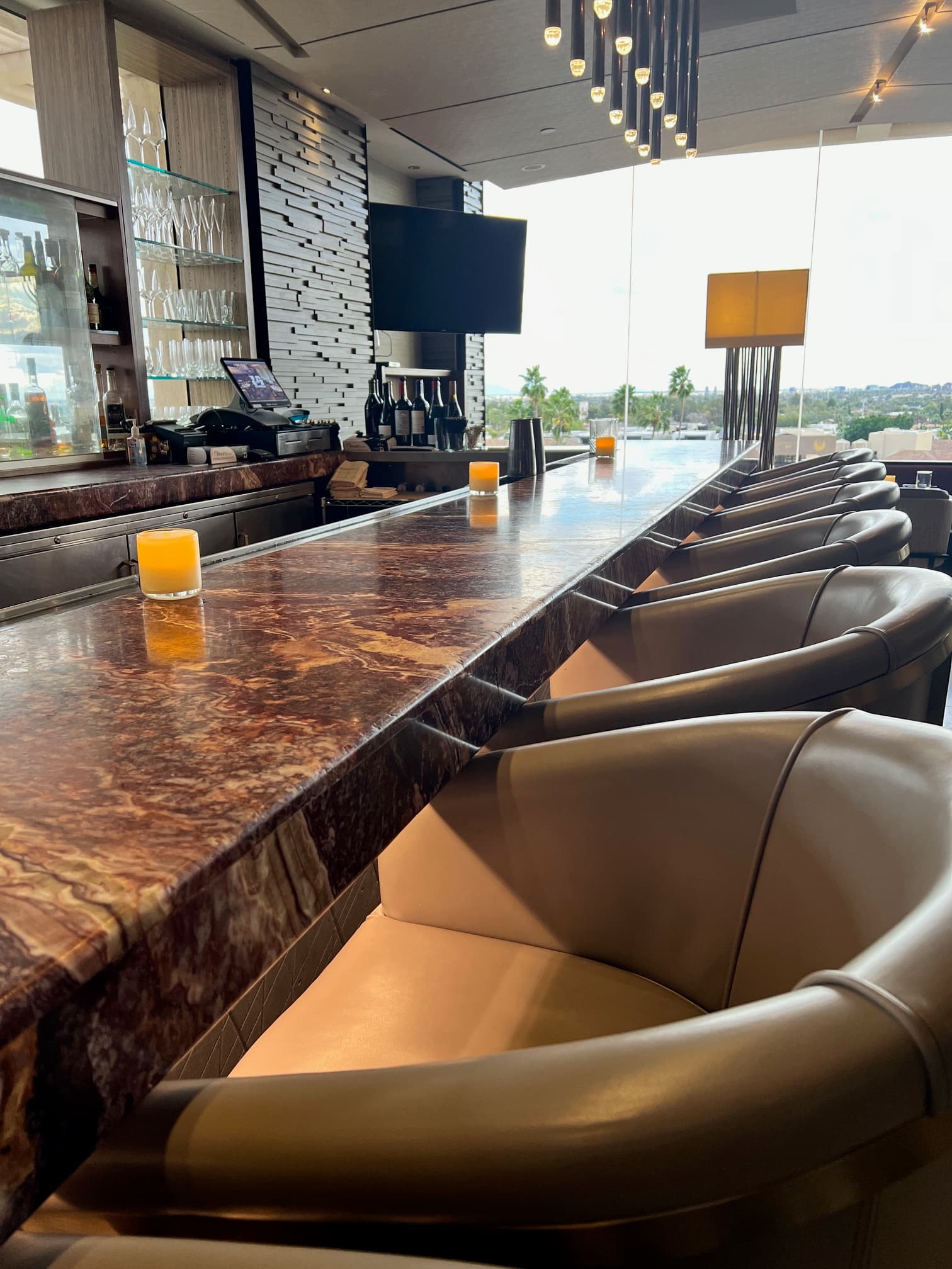 The lounge at The Phoenician with bar seats and chic lighting.