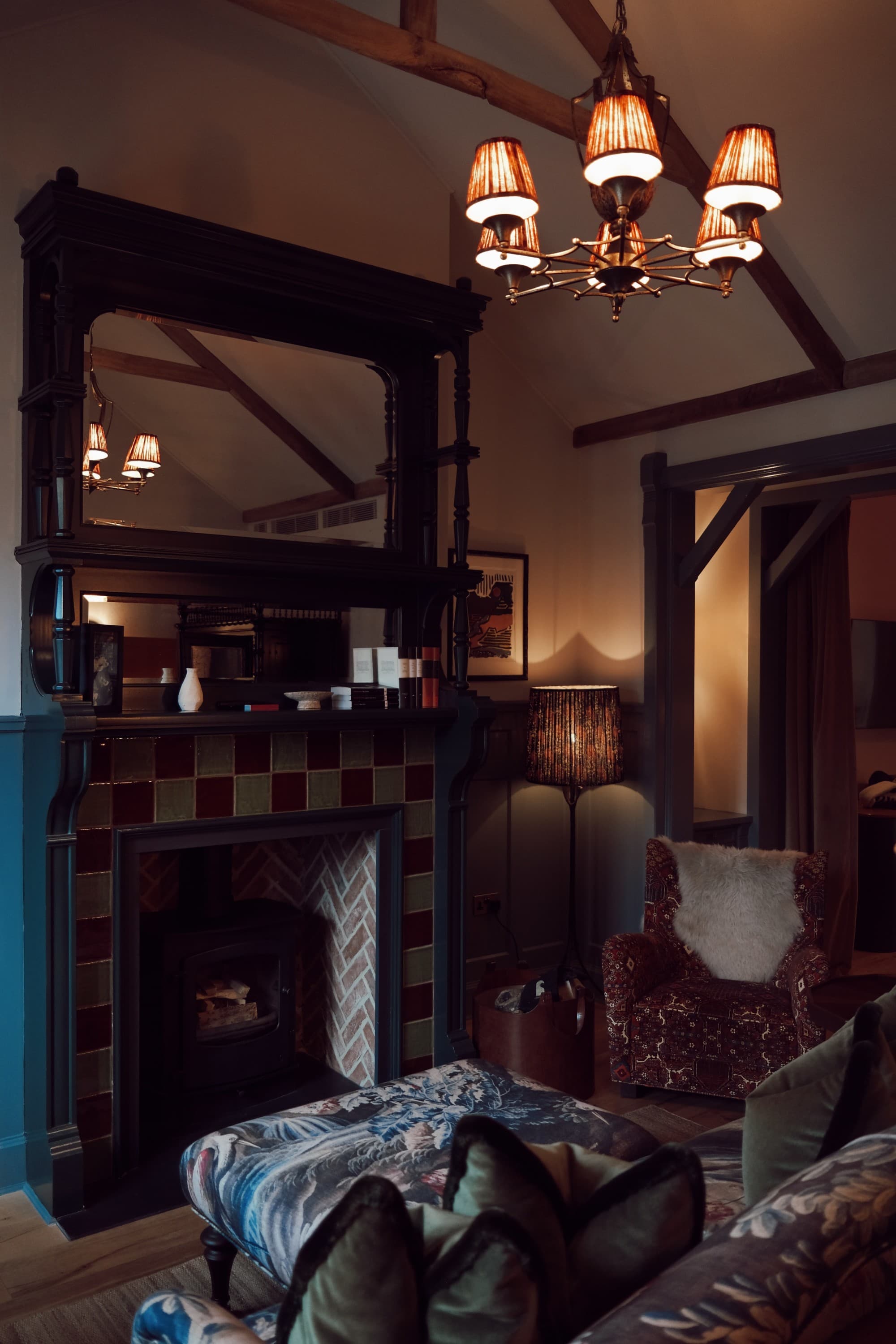 A seating area in front of a fireplace in a dimly-lit room