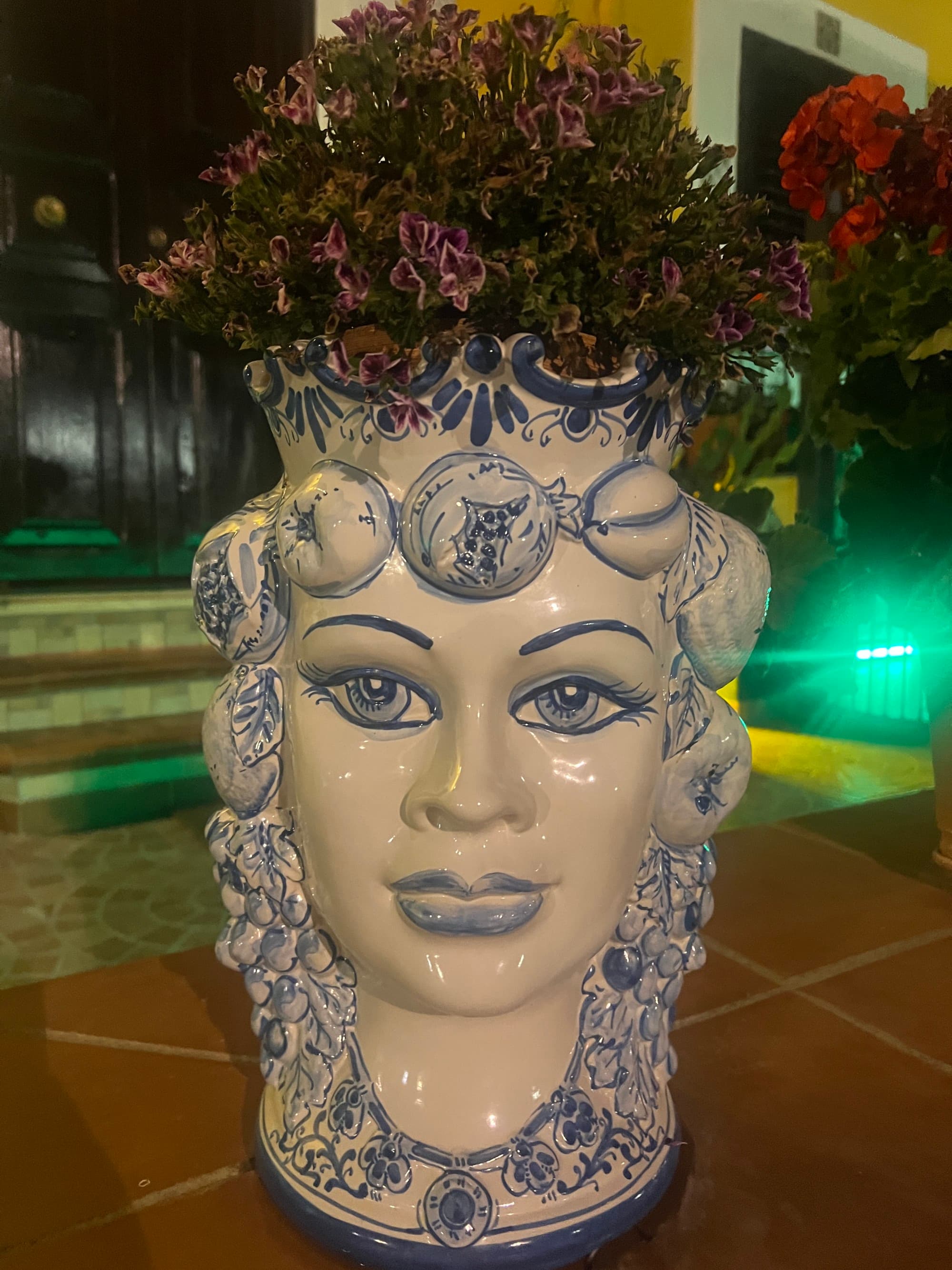 Image of ceramic blue and white head flower pot with pink flowers