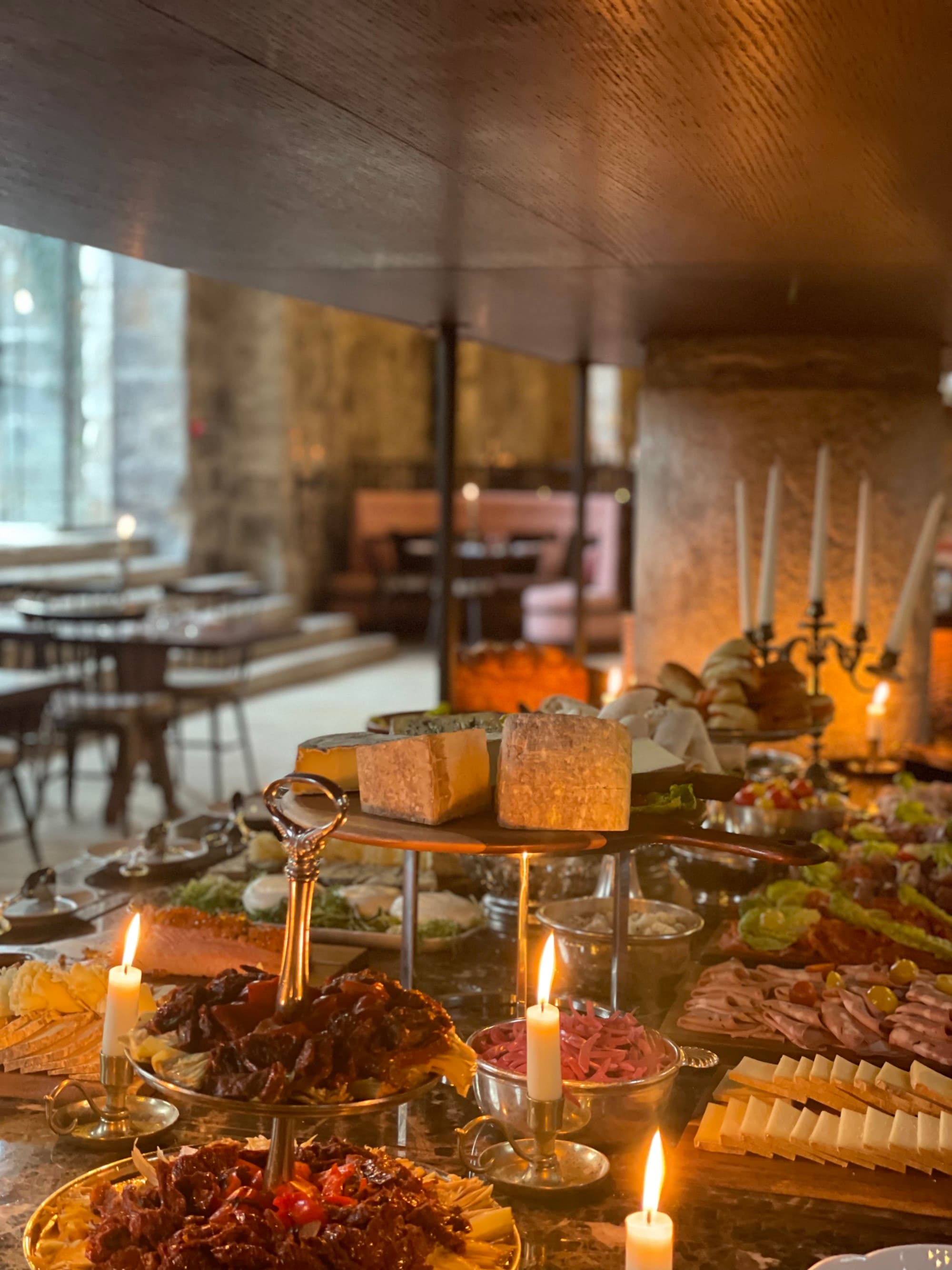A view of a table full of abundant food selections and candle lighting.