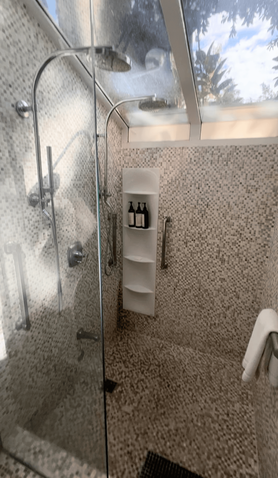 A stone shower with skylights and beige tiling.