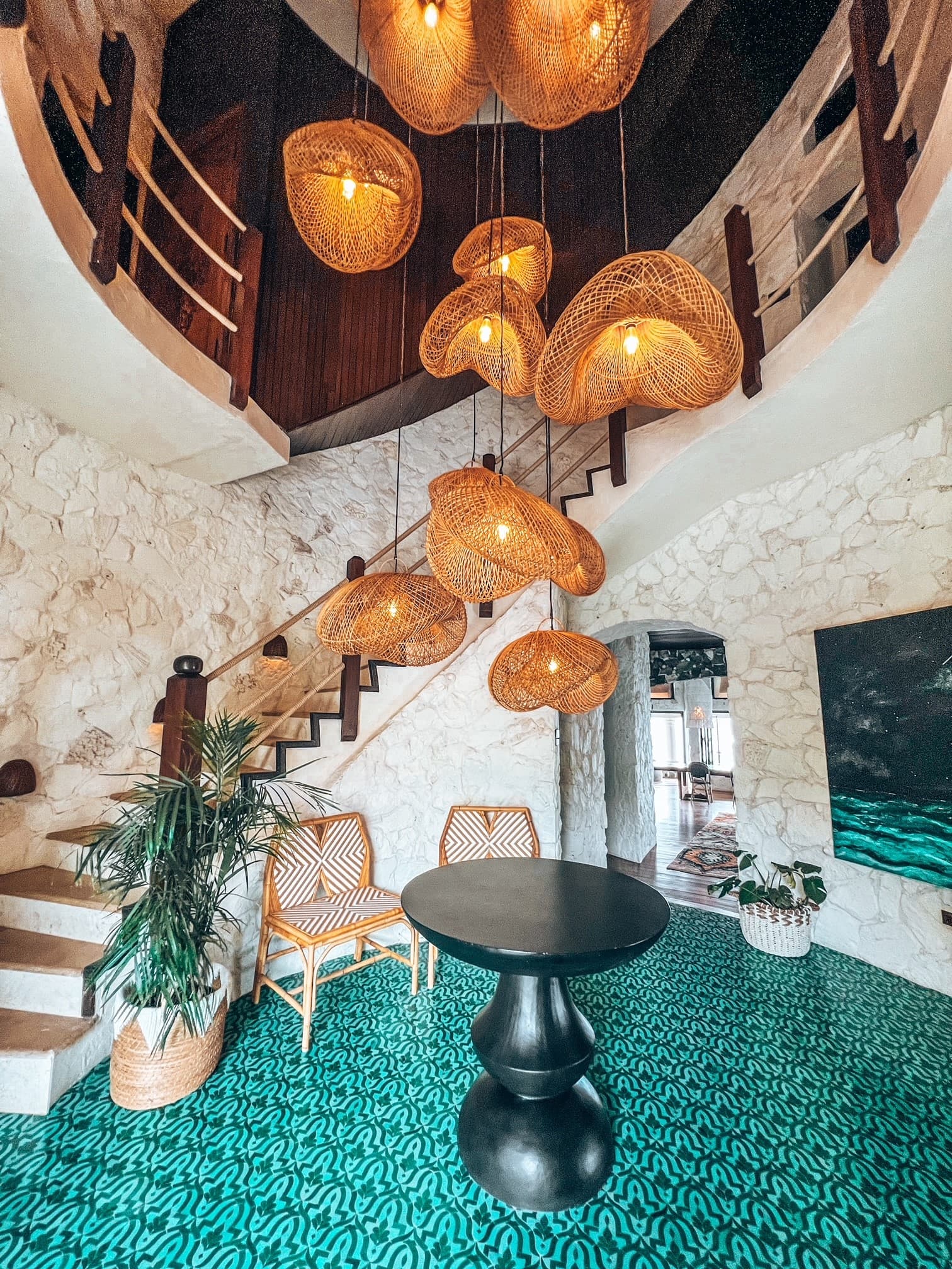 A round room with a tall staircase and an intricate chandelier