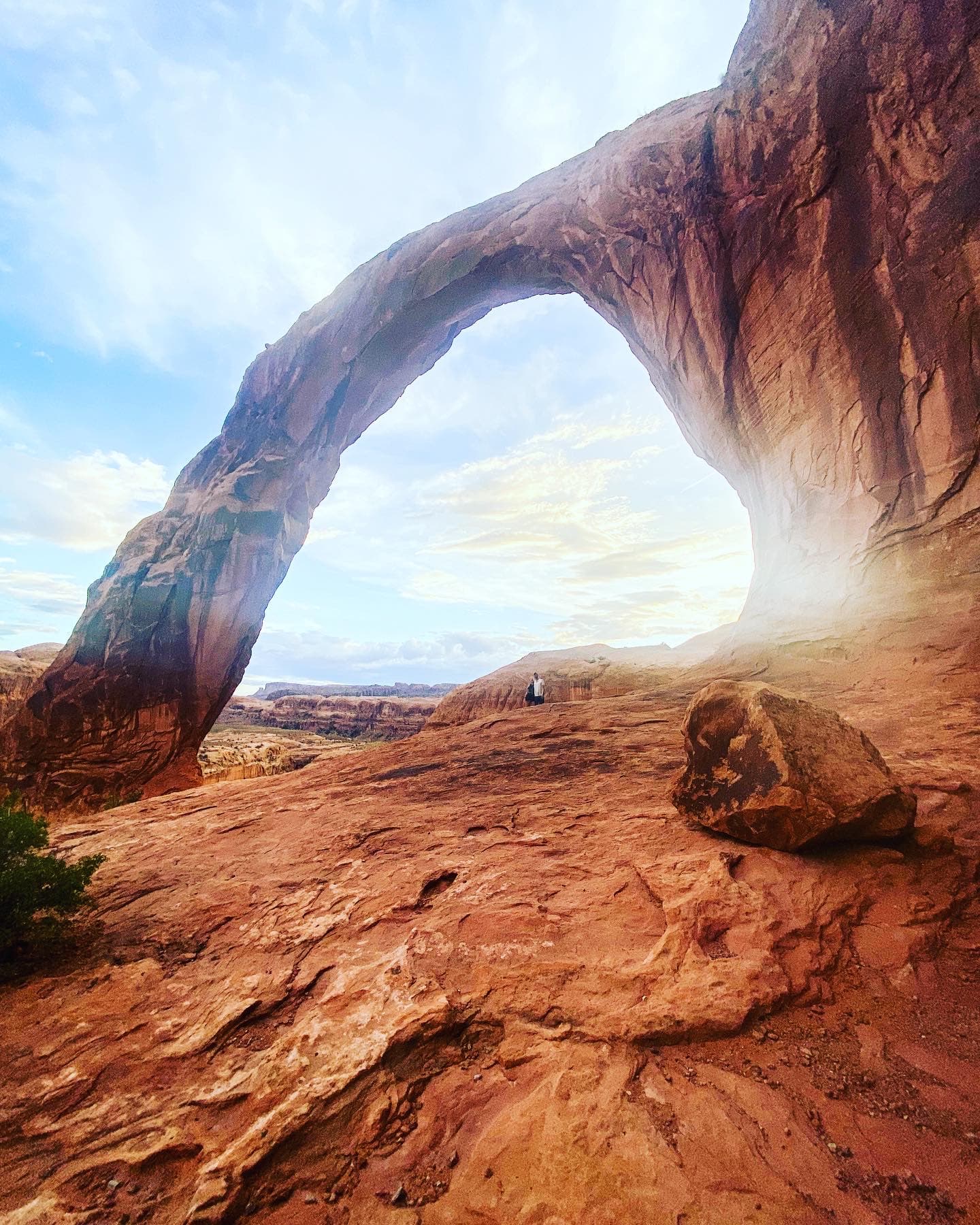 An arched rock formation in a desert during daytime