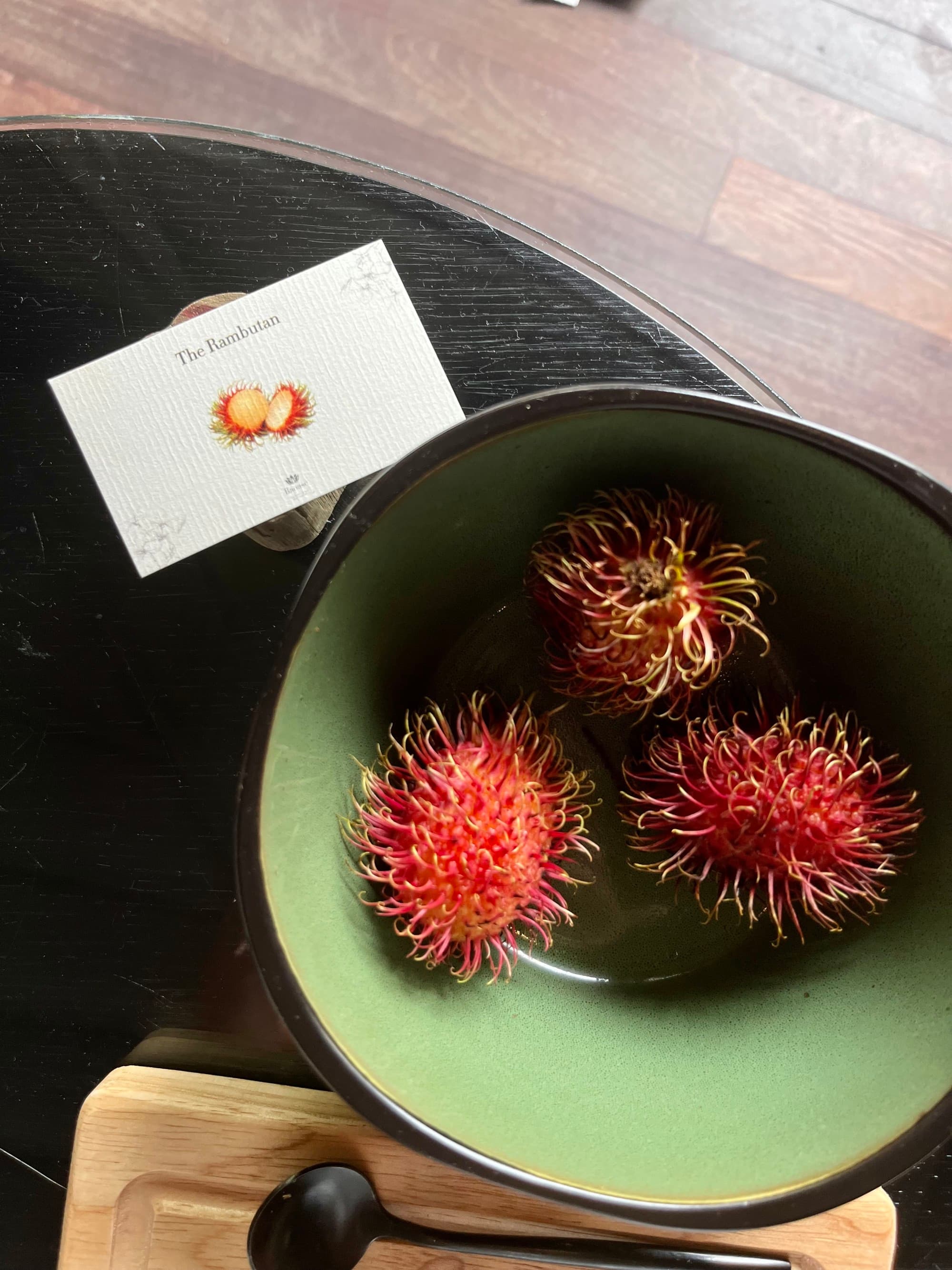 A bowl of rambutan fruit, a red and spiky fruit