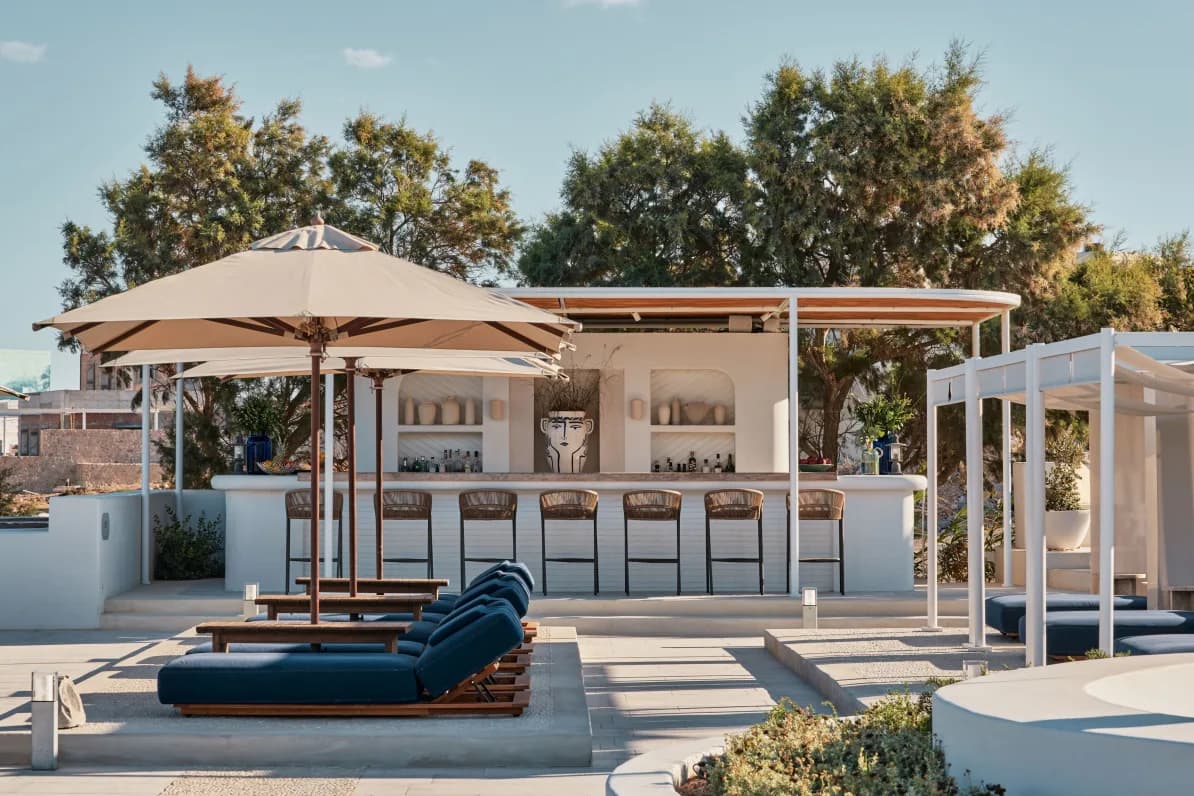outdoor beach club with navy blue loungers and a white bar