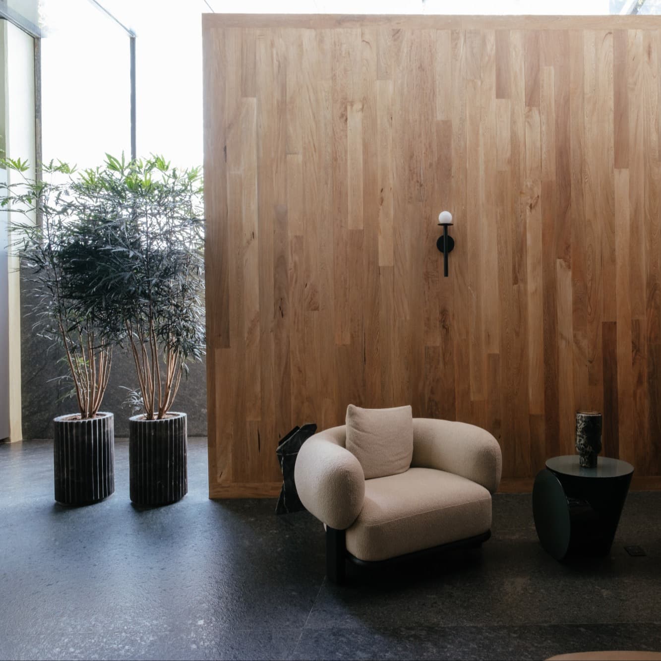 two plush chairs in front of a wooden wall