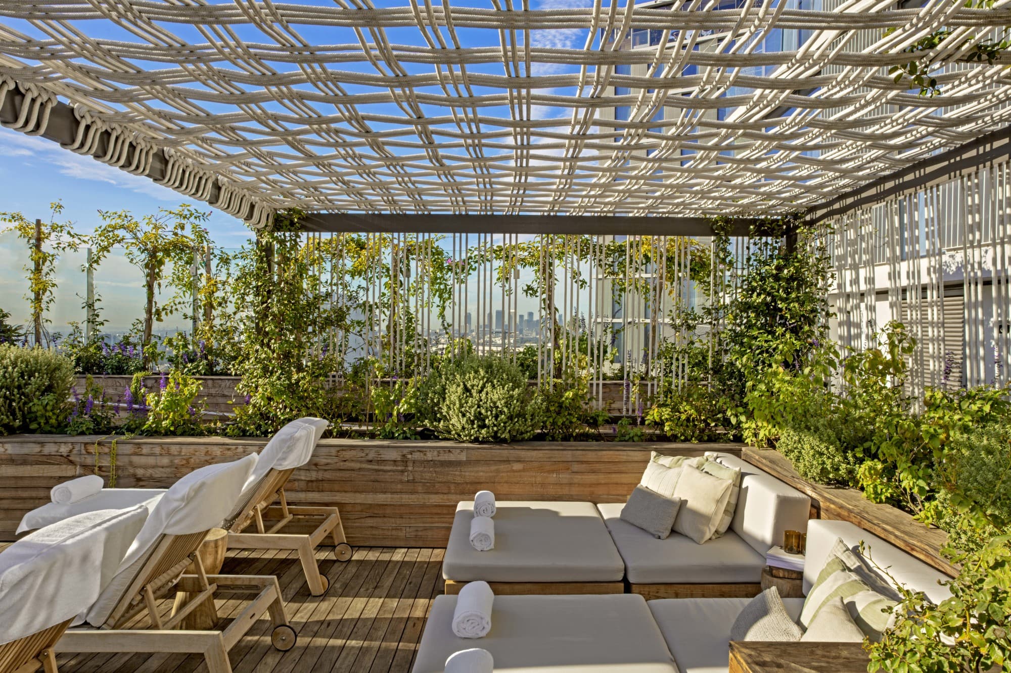 gray loungers under a sunny veranda covered in greenery