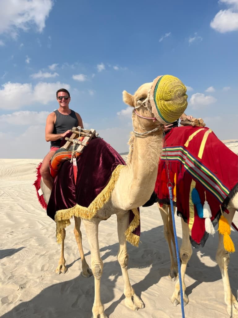 Travel advisor riding a camel in a desert