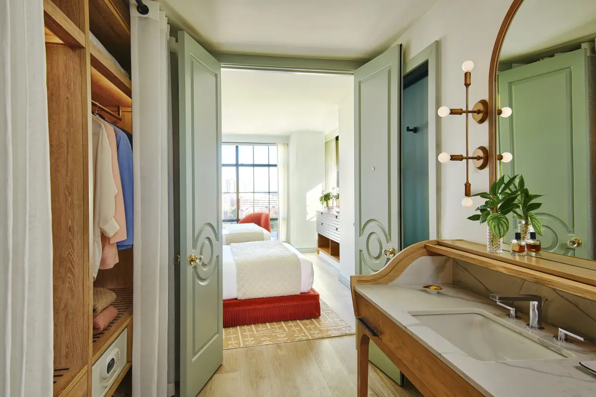 view of two beds with red trim through a turquoise closet door