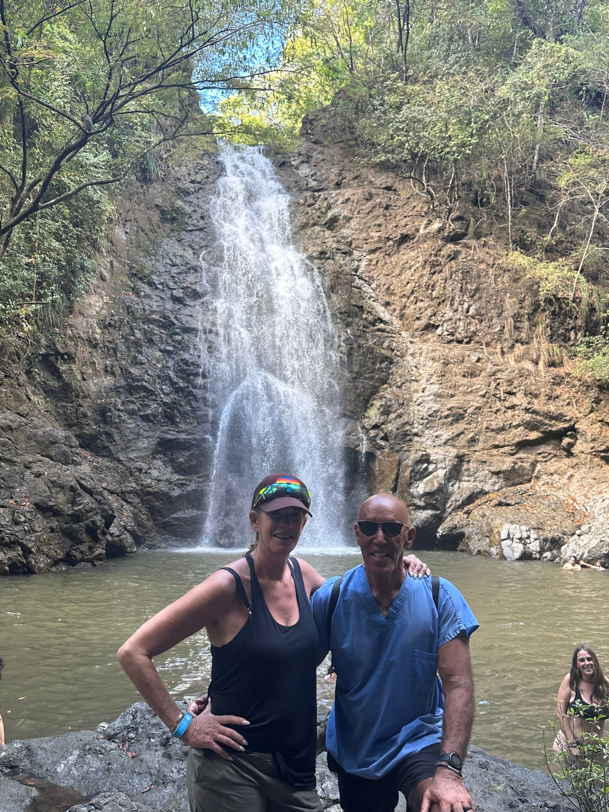 Couple posing in front of a waterfall
