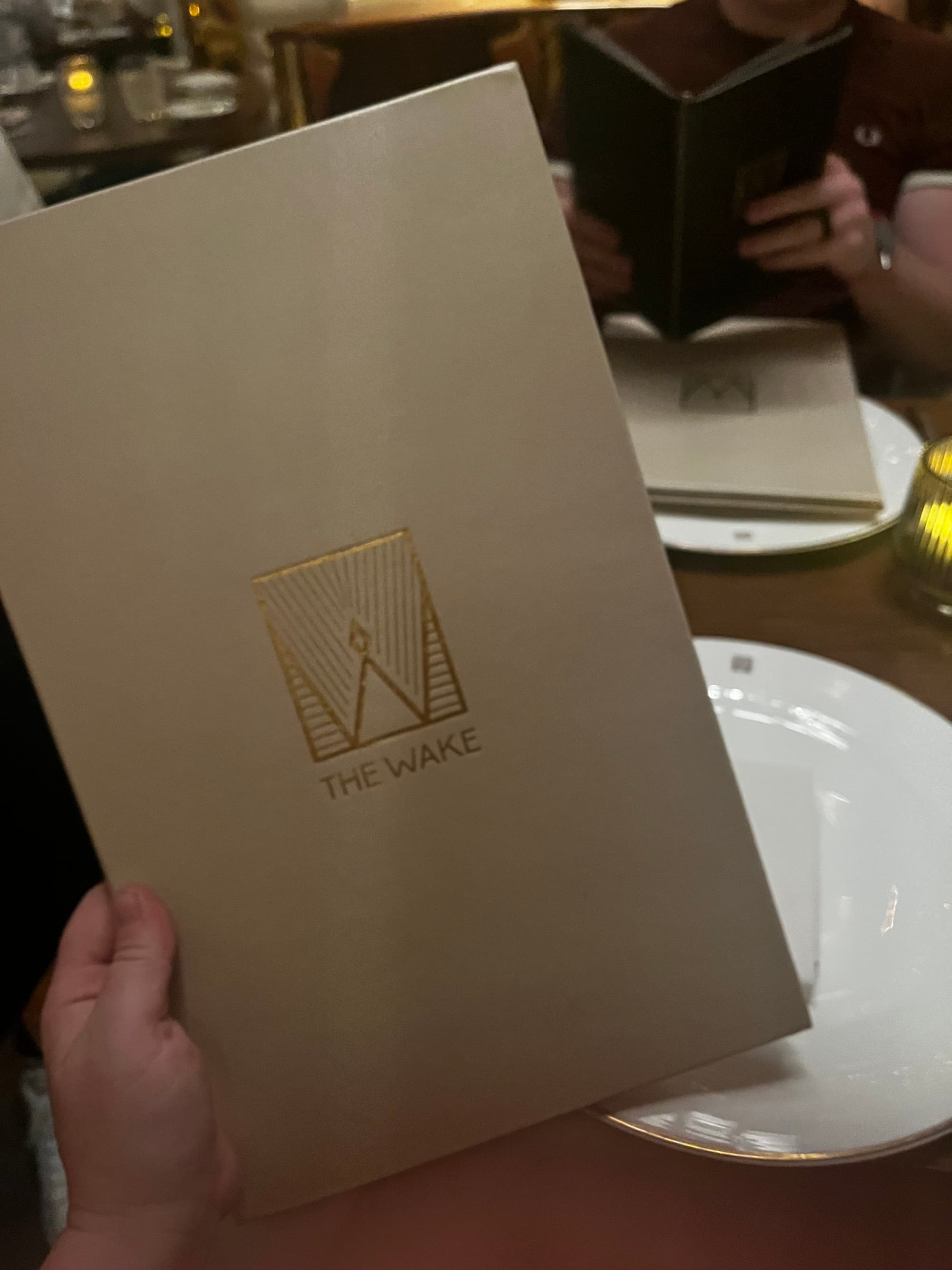The food menu in off-white with a golden logo