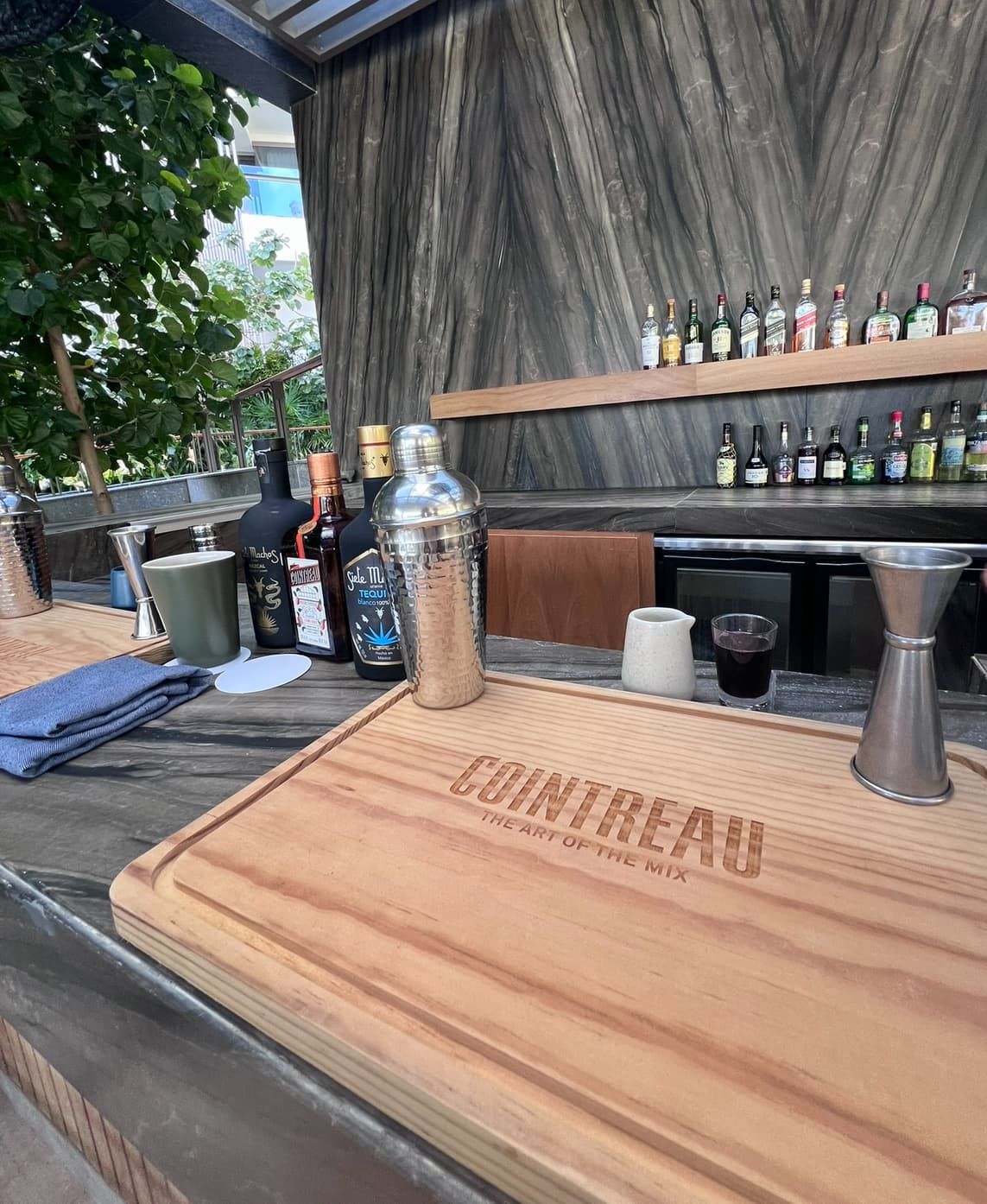 A bar complete with a wooden cutting board and margarita making supplies.