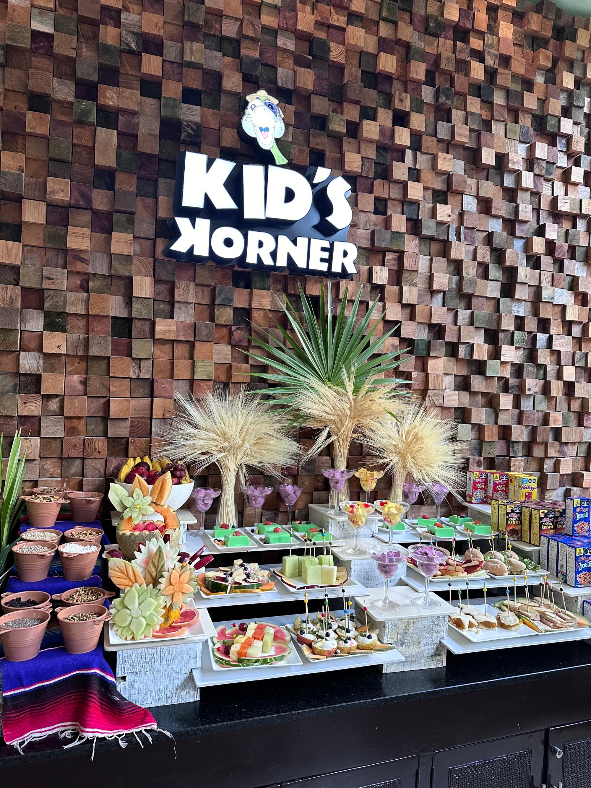 A food display area with a sign on the wall reading "Kid's Korner"