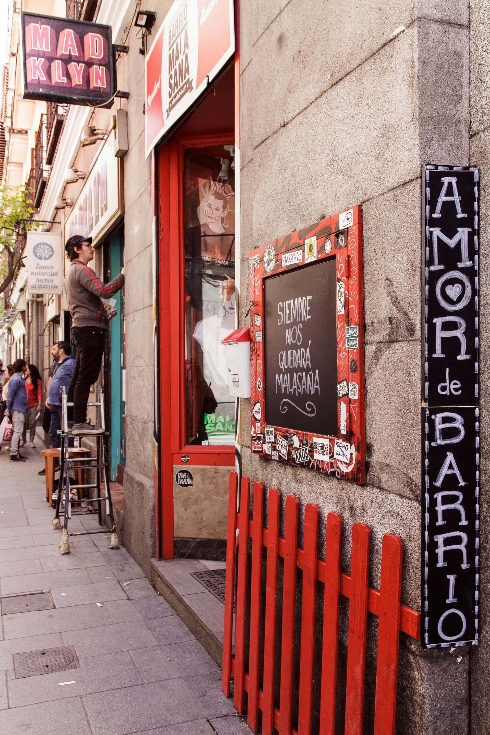 a man stands on a stool on an urban street