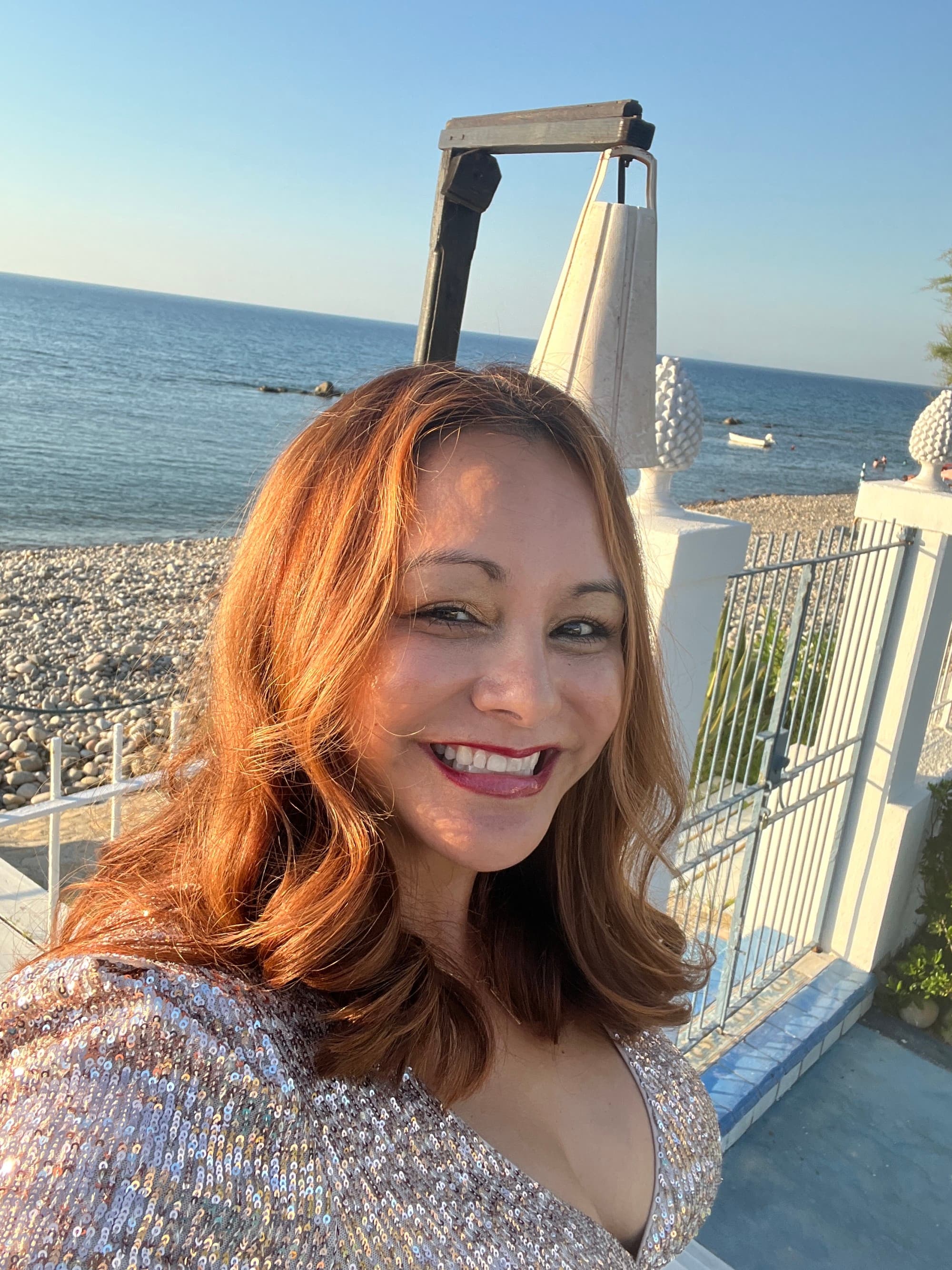 April Bueno dressed up for disco dinner posing in front of the beach