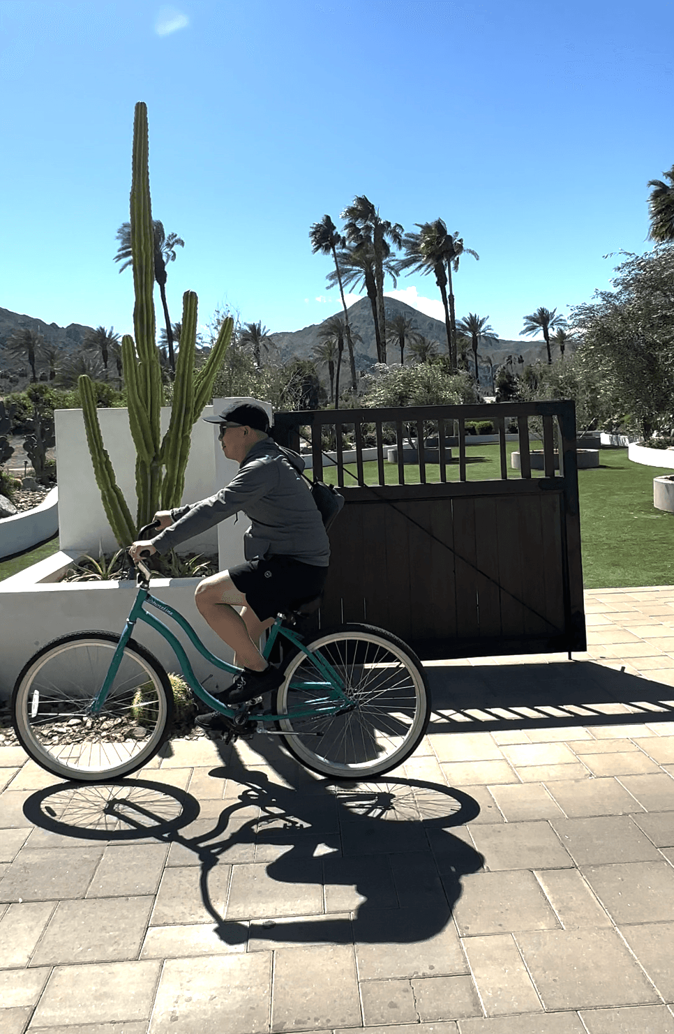 A person riding a bike outside on a brick path during the daytime