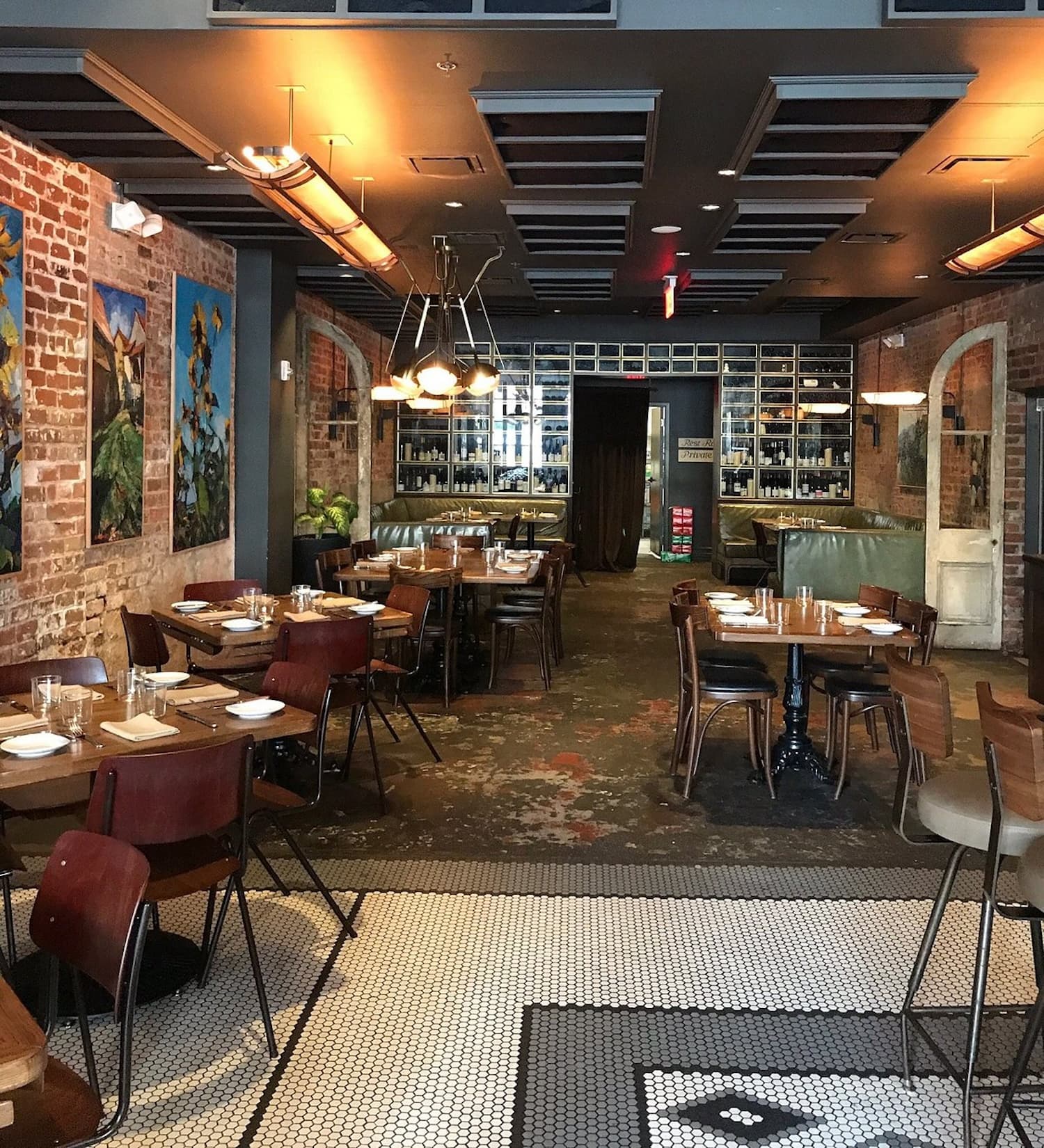 The restaurant at the Old No. 77 Hotel, New Orleans with exposed brick walls, brown tables and chairs and a warehouse feel