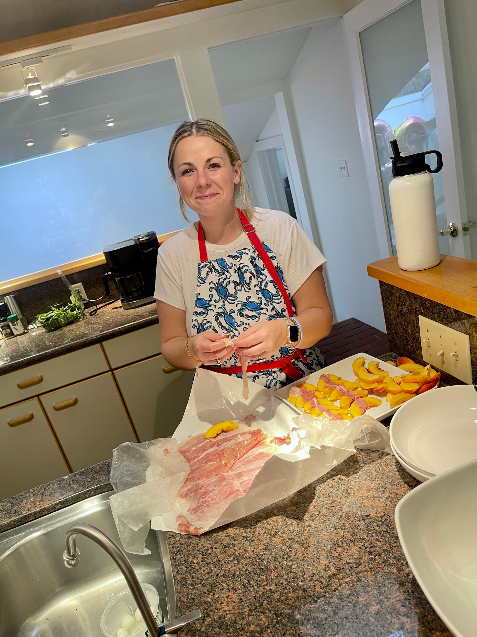 a woman in an apron cooks at a kitchen table