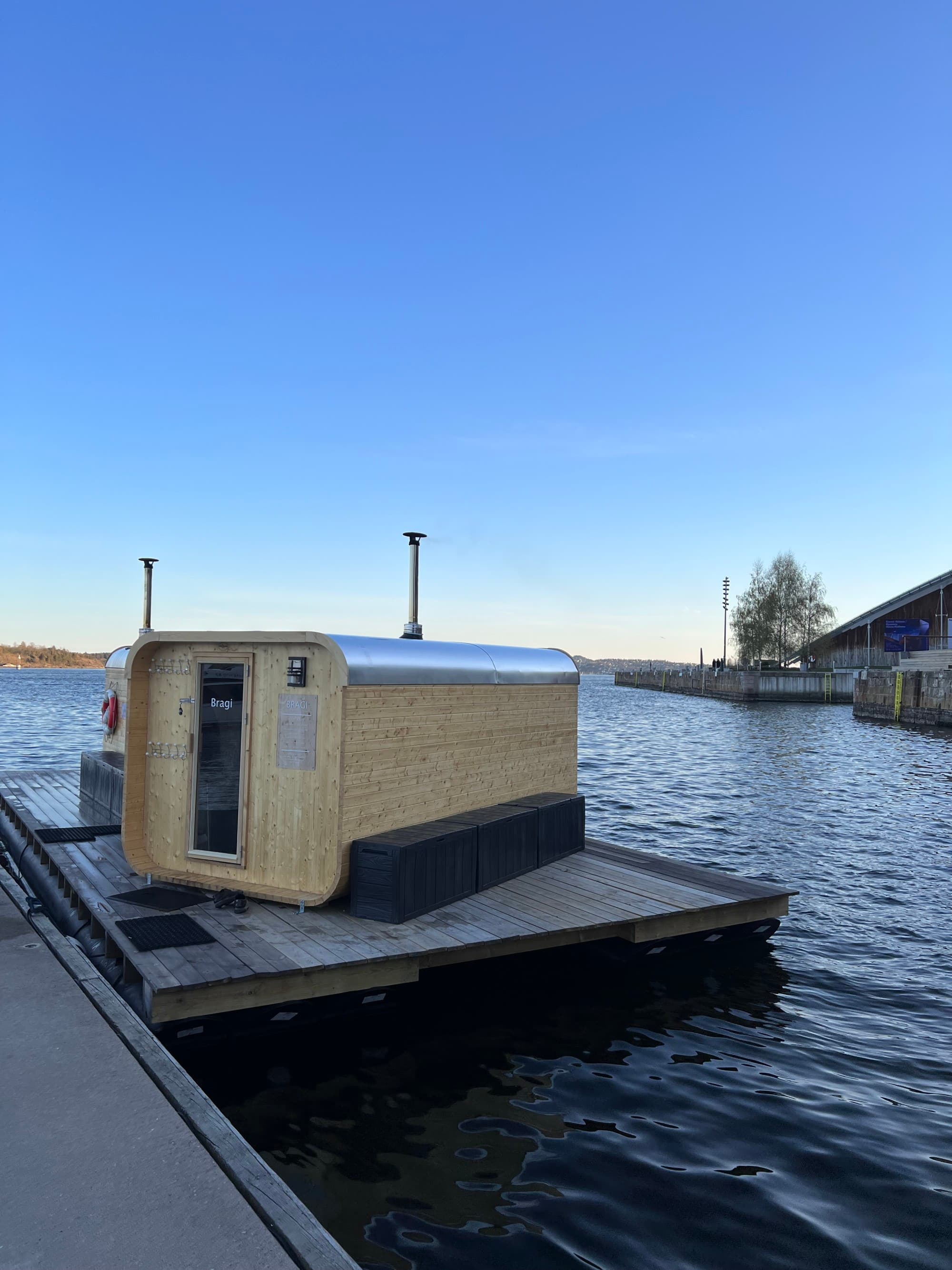 A body of water during the daytime with a small, wooden home on the pier
