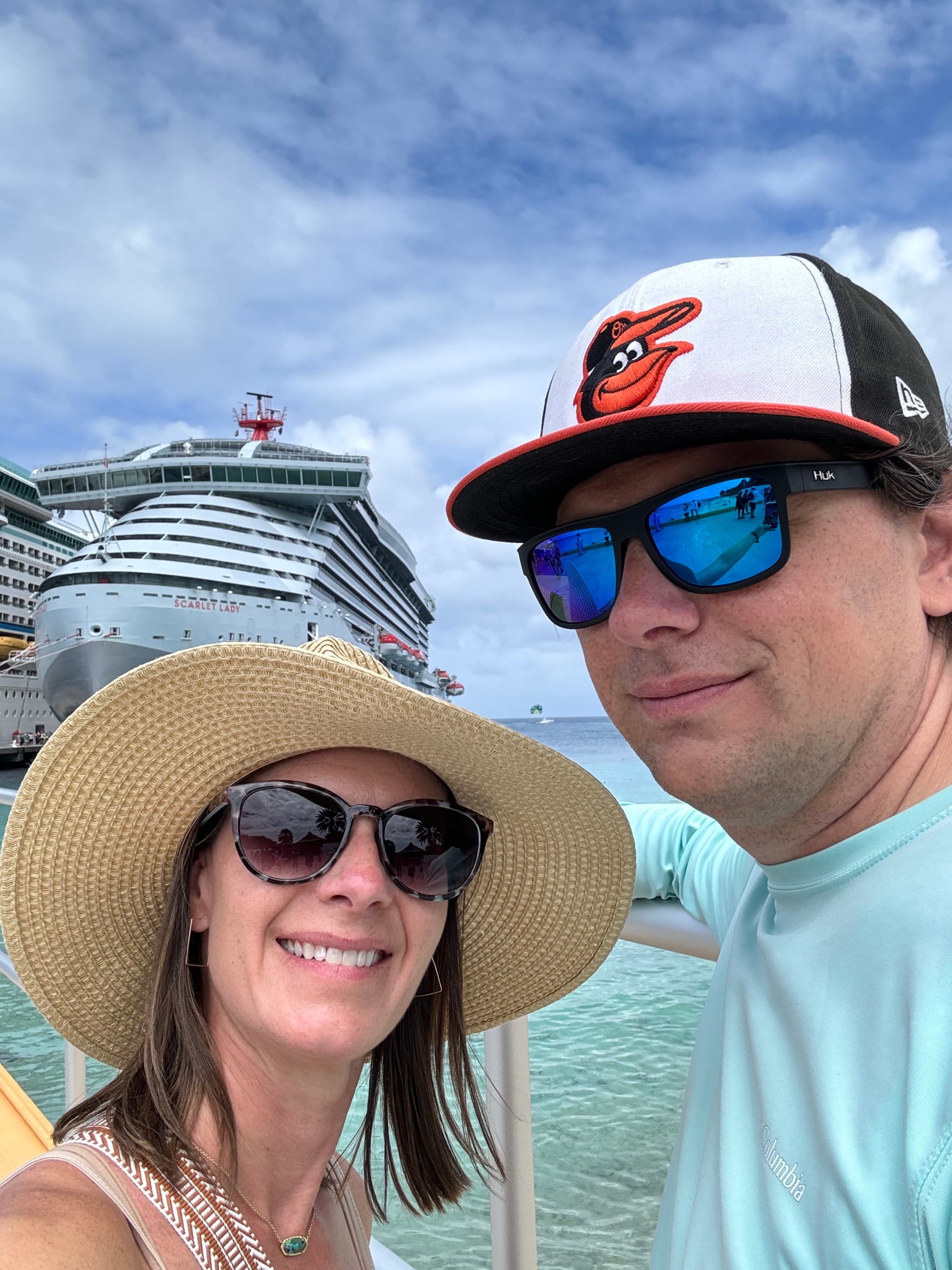 Travel advisor and husband before embarking on the cruise, with the ship and sea in the background.