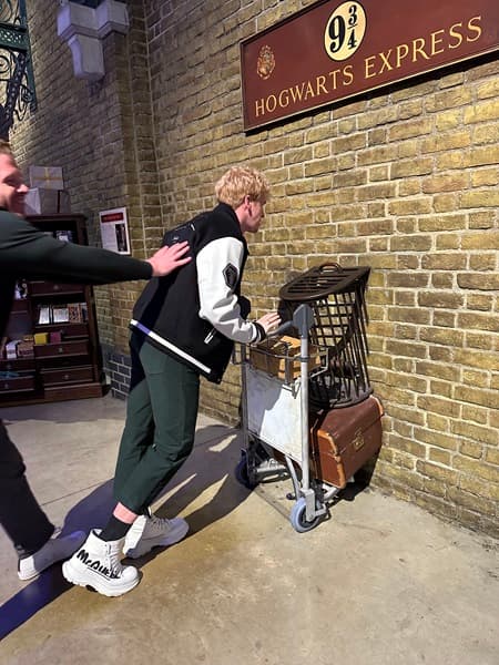 Travel advisor having fun on the Harry Potter Studio Tour, in front of the Hogwarts Express sign.