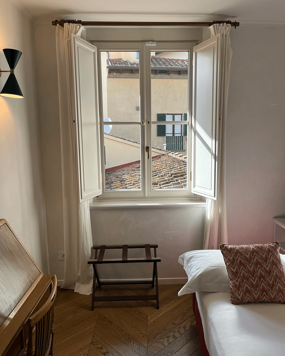 A hotel room with a small, open window