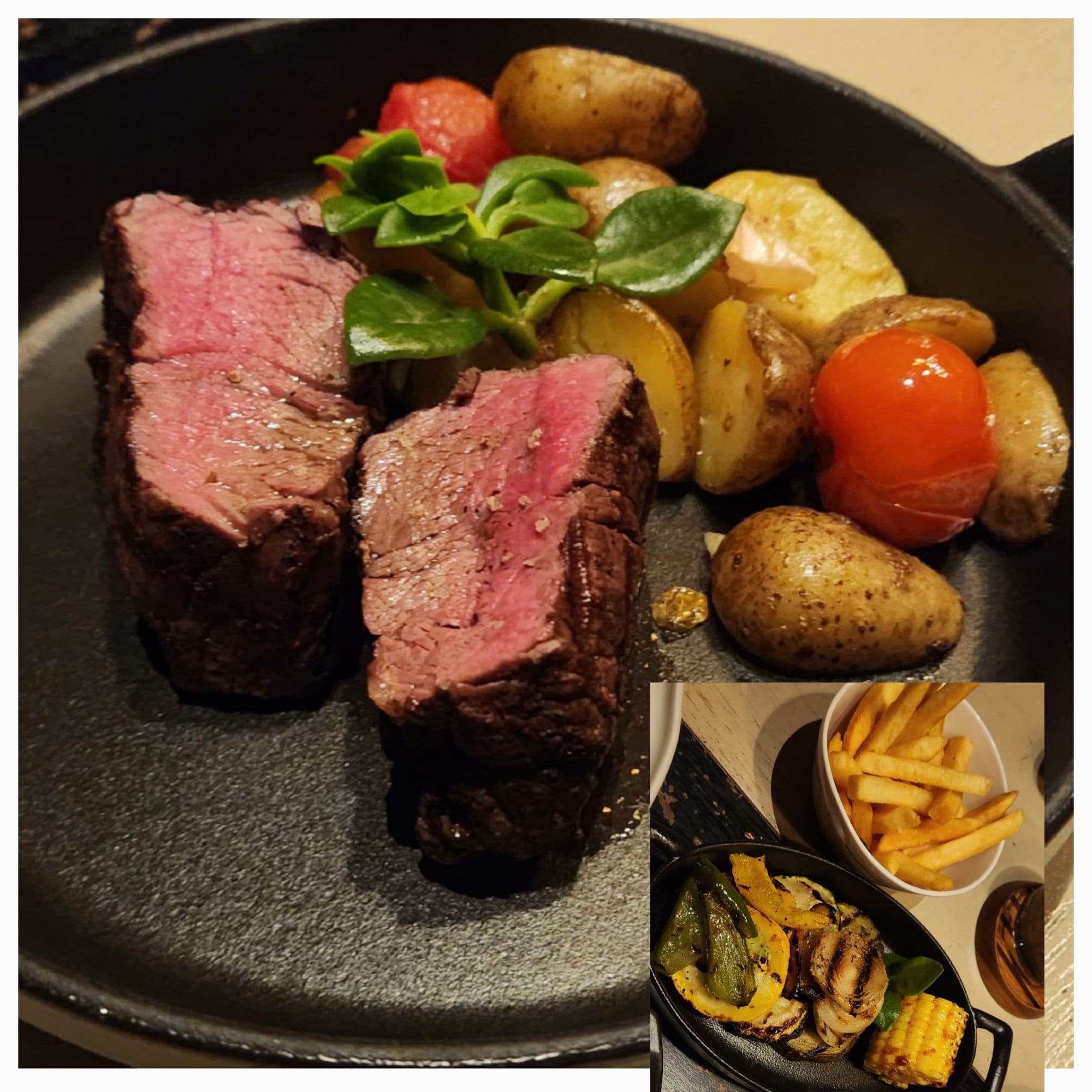 Meat and potatoes on a black plate