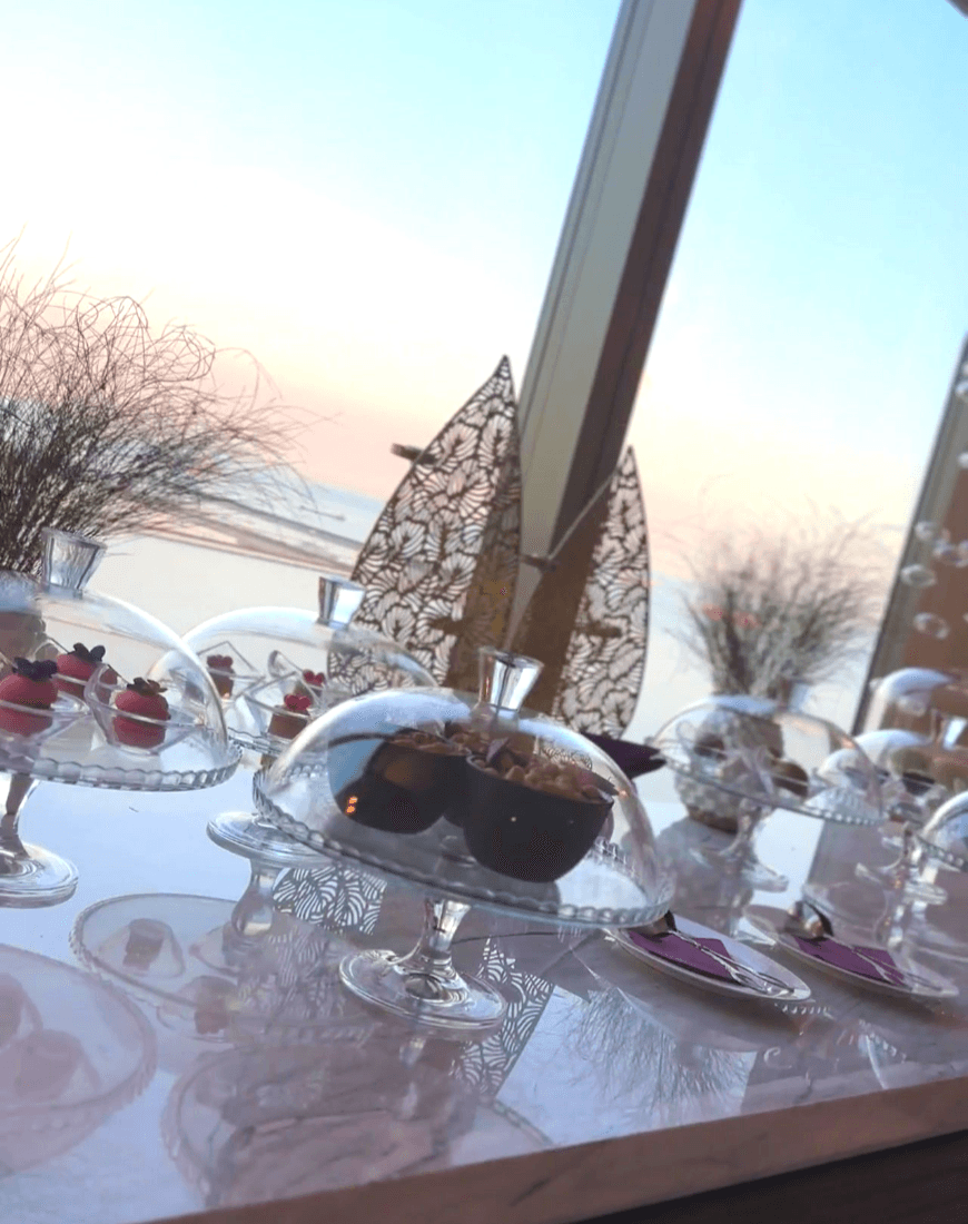Food in glass containers on a table in front of a window