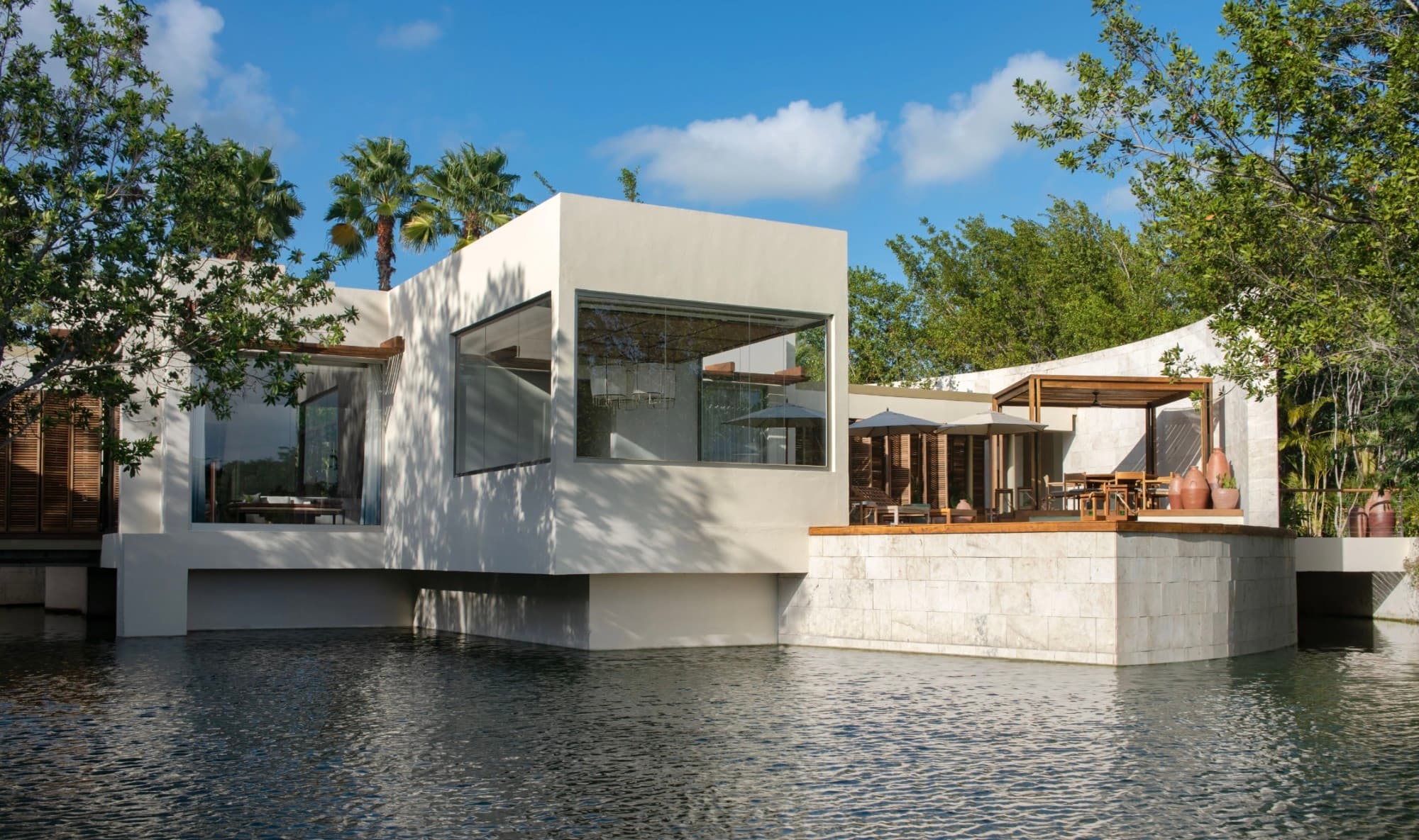 canal with contemporary house with terrace and trees and blue sky