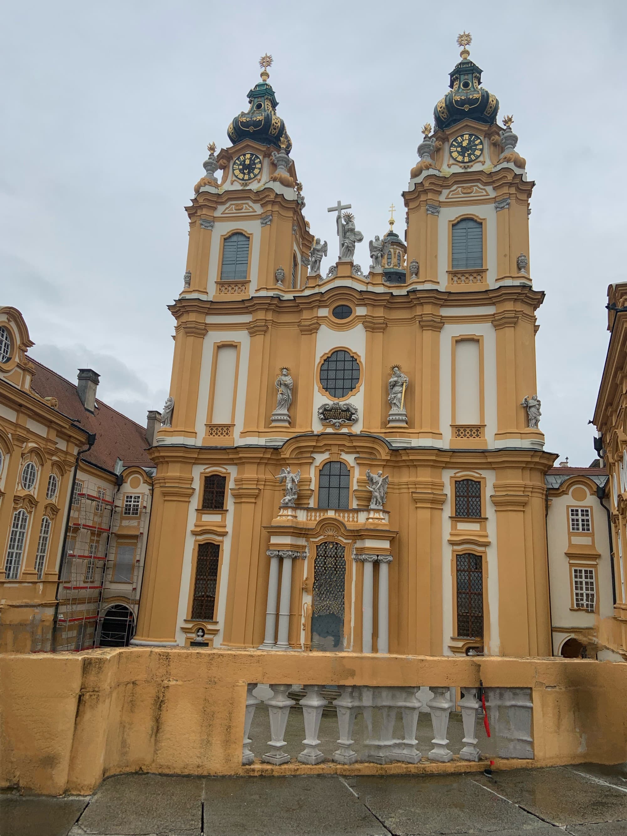 An orange and white colored building with ornate architecture and two turrets.