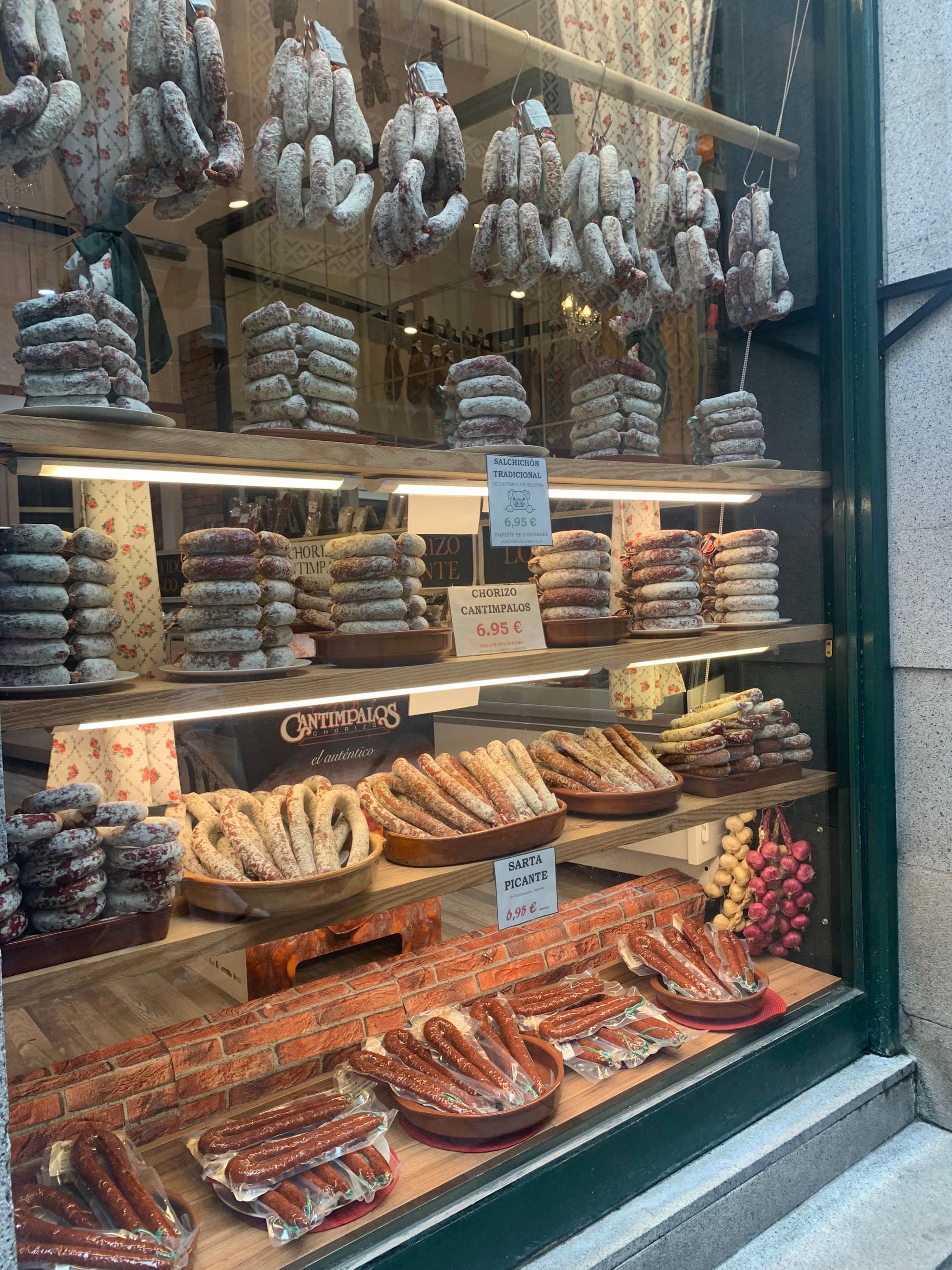 Butcher window displaying cured ham.