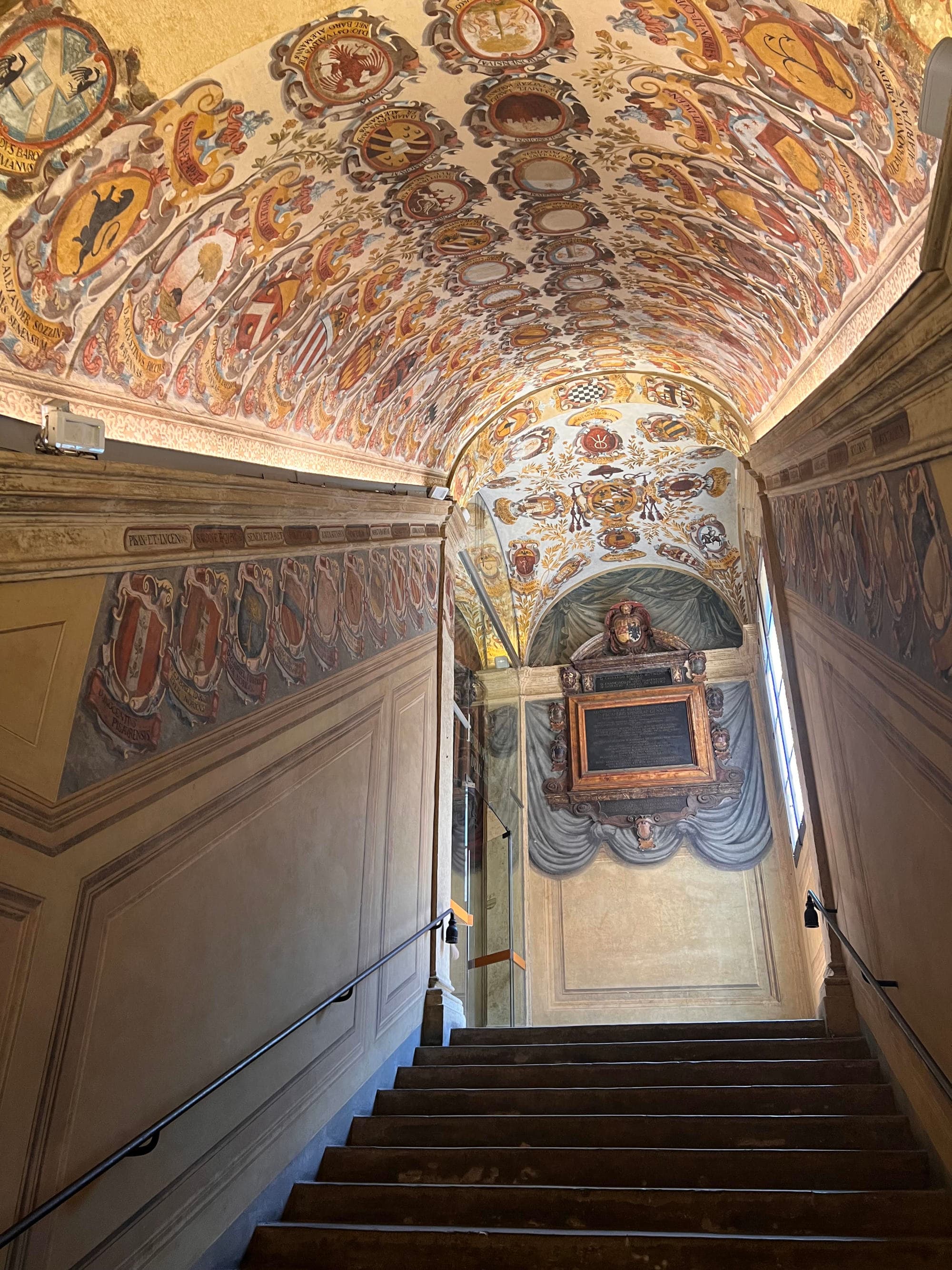 A decorated arched ceiling and stairs of a historical building.