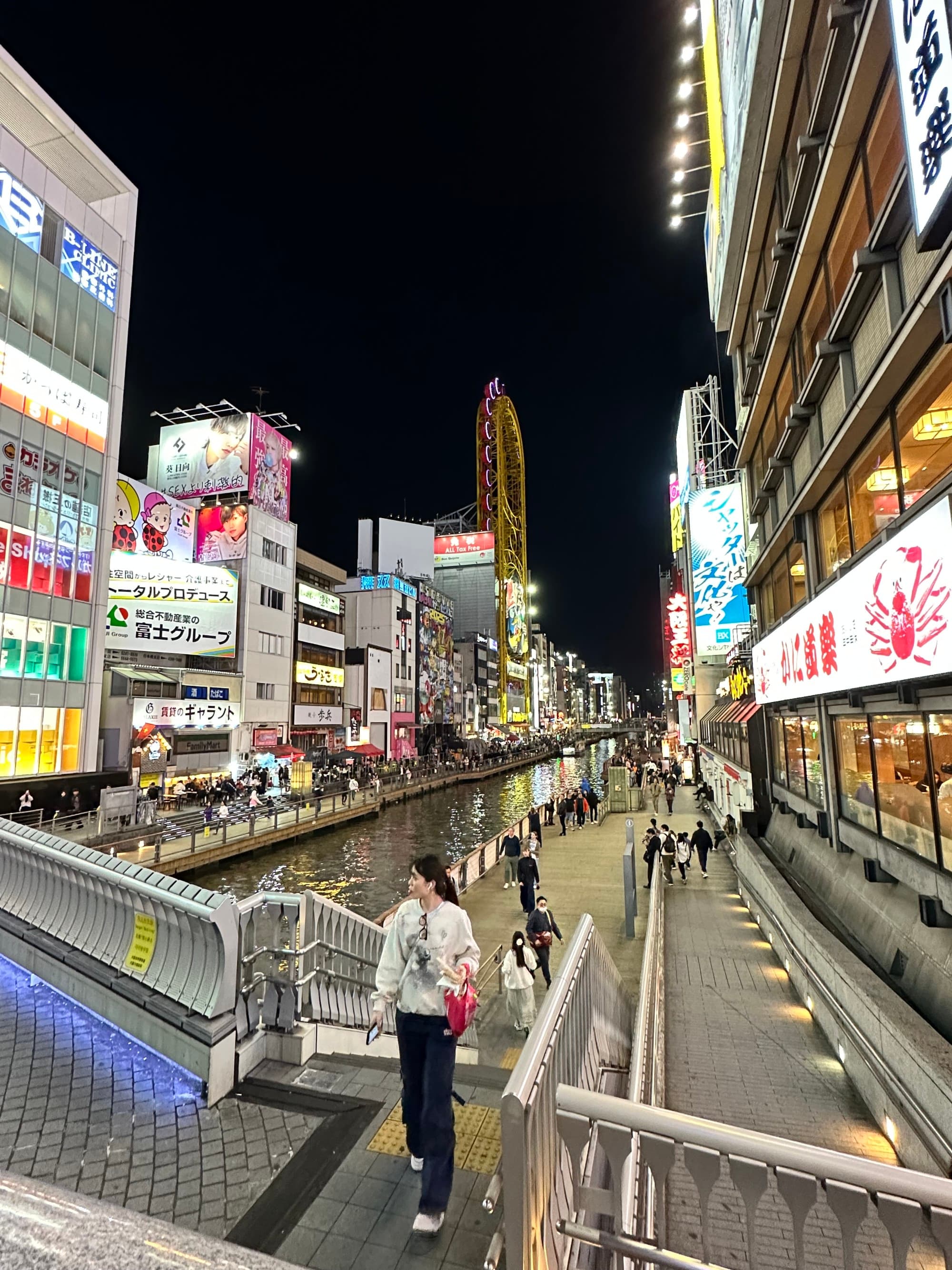 Advisor standing on a bridge at night with city buildings behind.