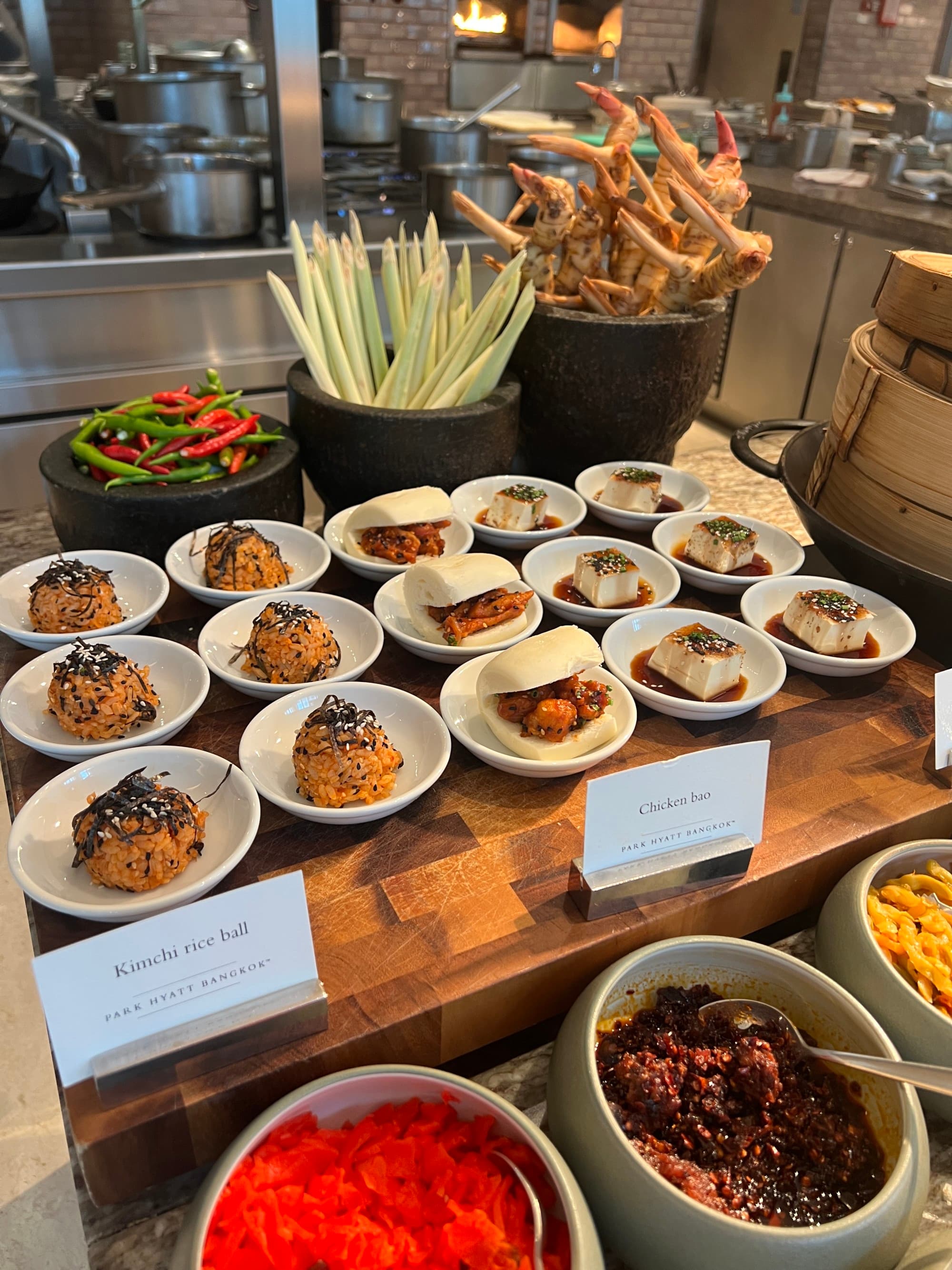 Food view, lots of small circular plates with different dishes presented on a wooden table.